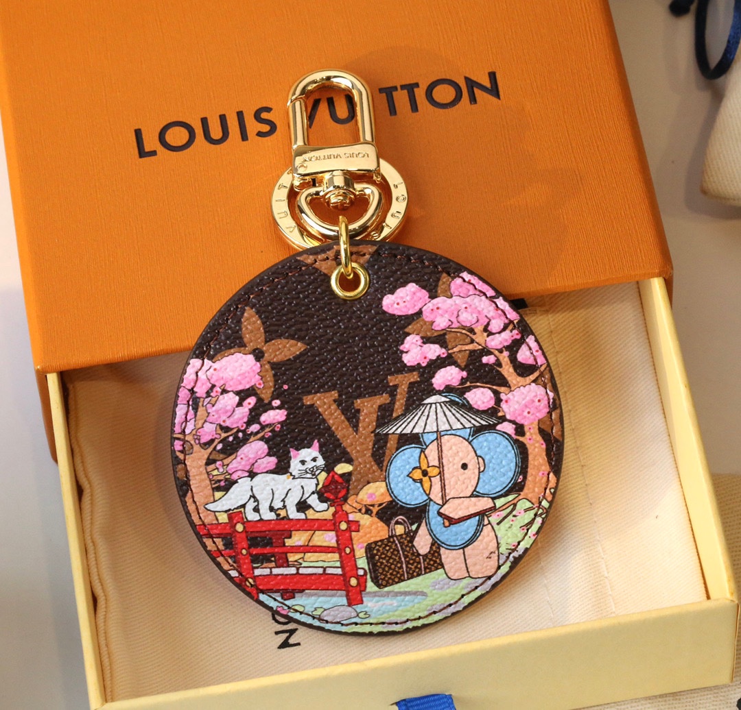 Close-up of a cute cat in cherry blossoms on a round coffee-colored pendant.