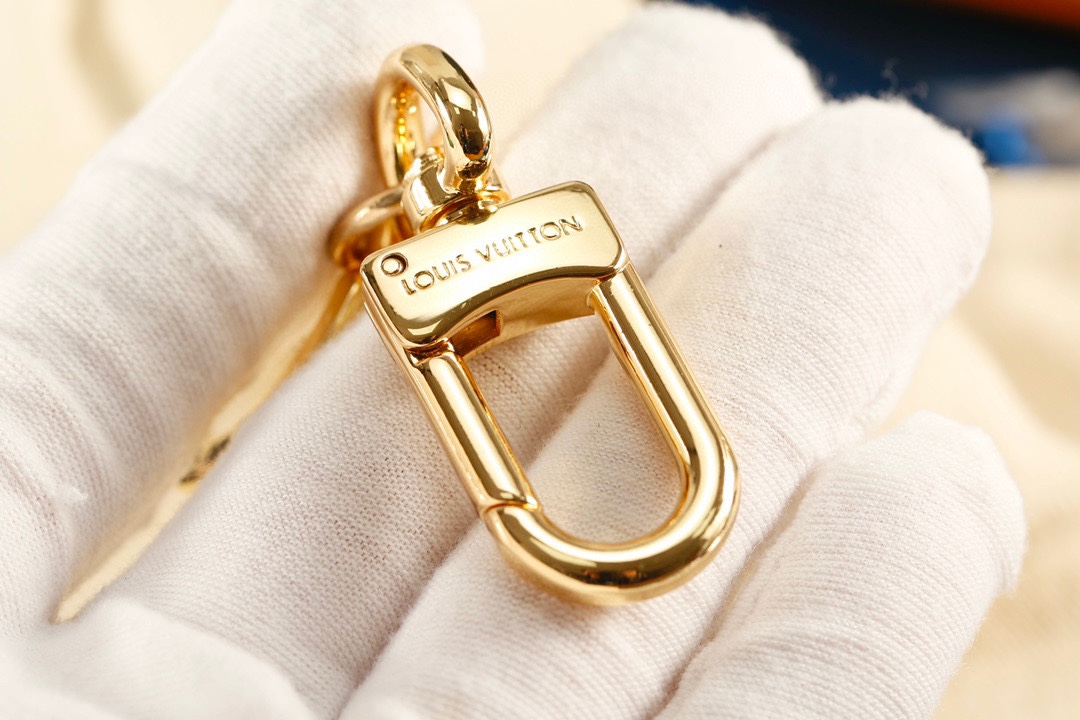 Gold lock keychain attached to a bag
