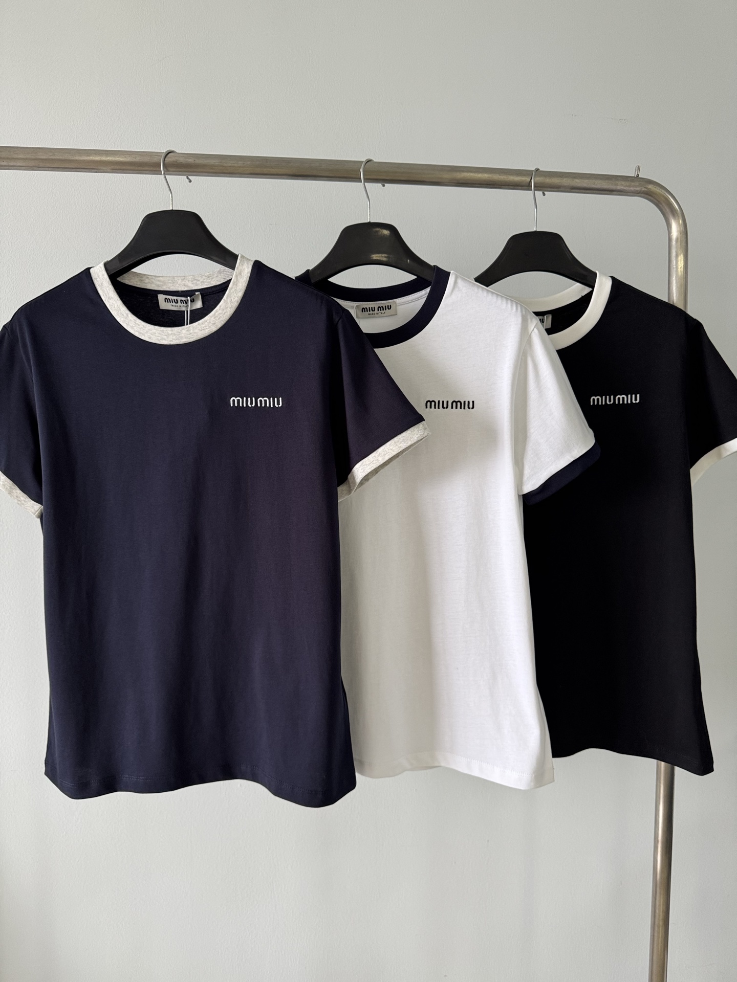 NO:320201,170MIUMI* 2025SS New Contrast color edging design letter embroidered short-sleeved T-shirt, customized YB native cotton material, breathable and comfortable, full texture, three-dimensional cut, highlighting the brand style, made of pure cotton fabric, smooth feel, comfortable skin, loose and casual style, presenting a slimming visual effect, the neckline cuffs are designed with contrasting color edging, the right side of the chest makes the simple style shine and eye-catching, and easily shows the high-end style. The single wear inner wear is brilliant and fashionable. Customized surface accessories. Accurate version. High version. Color hidden blue. White. Black. SML 3.,miumiu. T-shirt,tees. t-shirt,alexander wang.19860909170MIUMI* 2025SS 新款 撞色包边设计字母刺绣短袖T恤,定制YB原生全棉材质 透气舒适 质感十足 立体裁剪 凸显品牌格调 采用纯棉面料制成 手感顺滑 贴肤舒适 宽松休闲版型 呈现显瘦视觉效果 领口袖口以撞色包边作设计亮点 胸前右侧标志性字母刺绣装饰 让简单的款式 秒变得闪耀吸睛 轻松彰显高级格调 单穿内搭都出彩时髦 定制面辅料 认准版本 高版本 颜色藏蓝 白色 黑色 码数SML 3,,miumiu,T-shirt,tees，t-shirt,alexander wang,Women's clothing