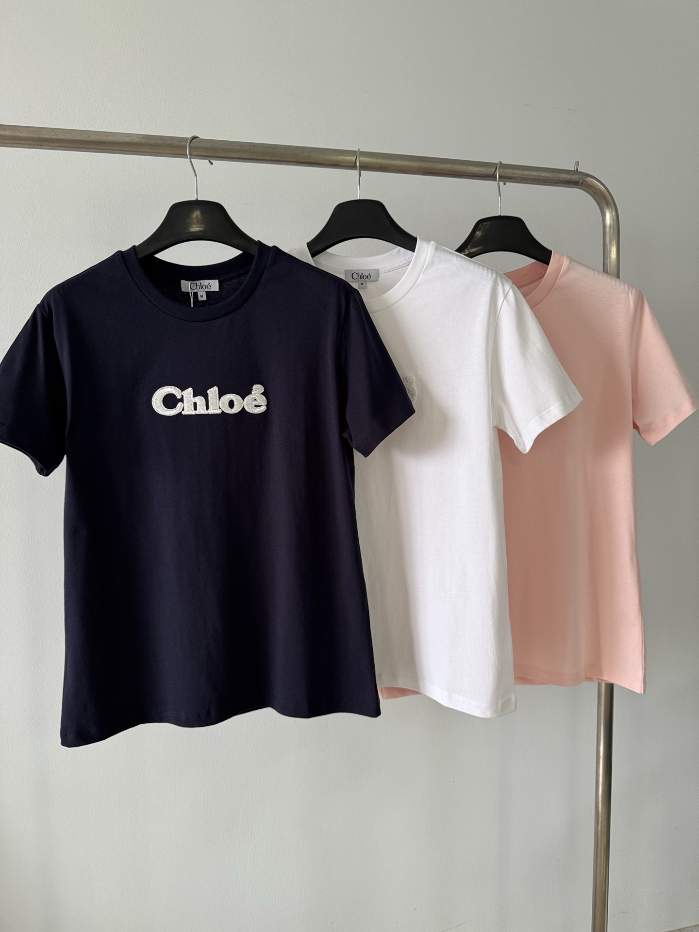 NO:320188,Chloe's new spring and summer style, three-dimensional embroidered letters decorative pure cotton short-sleeved T-shirt, customized YB twill cotton material, breathable and comfortable, full texture. Regular short-sleeved T-shirt cutting highlights the brand style and presents a slim visual effect. Three-dimensional embroidered letter decoration on the chest, fashionable and high-end feeling, customized imported high-gloss yarn with its own highlight effect, full high-end feeling, and it looks very luxurious and luxurious!  Overall relaxed and fashionable, and the inner wear is very outstanding. Customized surface accessories. Accurate version. High-version. Color pink. White. Black. SML., chloe, loewe. T-shirt. Tees. T-shirt. Tees. T-shirt. Alexander wang.19860909Chloe  春夏新款 立体万针刺绣字母装饰纯棉短袖T恤,定制YB斜纹全棉材质 透气舒适 质感十足 常规短袖T恤裁剪 凸显品牌格调 呈现显瘦视觉效果 胸前万针刺绣立体感字母装饰 时尚高级感立现 定制进口高光纱线 自带高光效果 高级感十足 看着就很奢华贵气！整体松弛时髦 单穿内搭都十分出彩 定制面辅料 认准版本 高版本  颜色粉色 白色 黑色 码数SML,,chloe,loewe,T-shirt,tees，t-shirt,alexander wang,Women's clothing