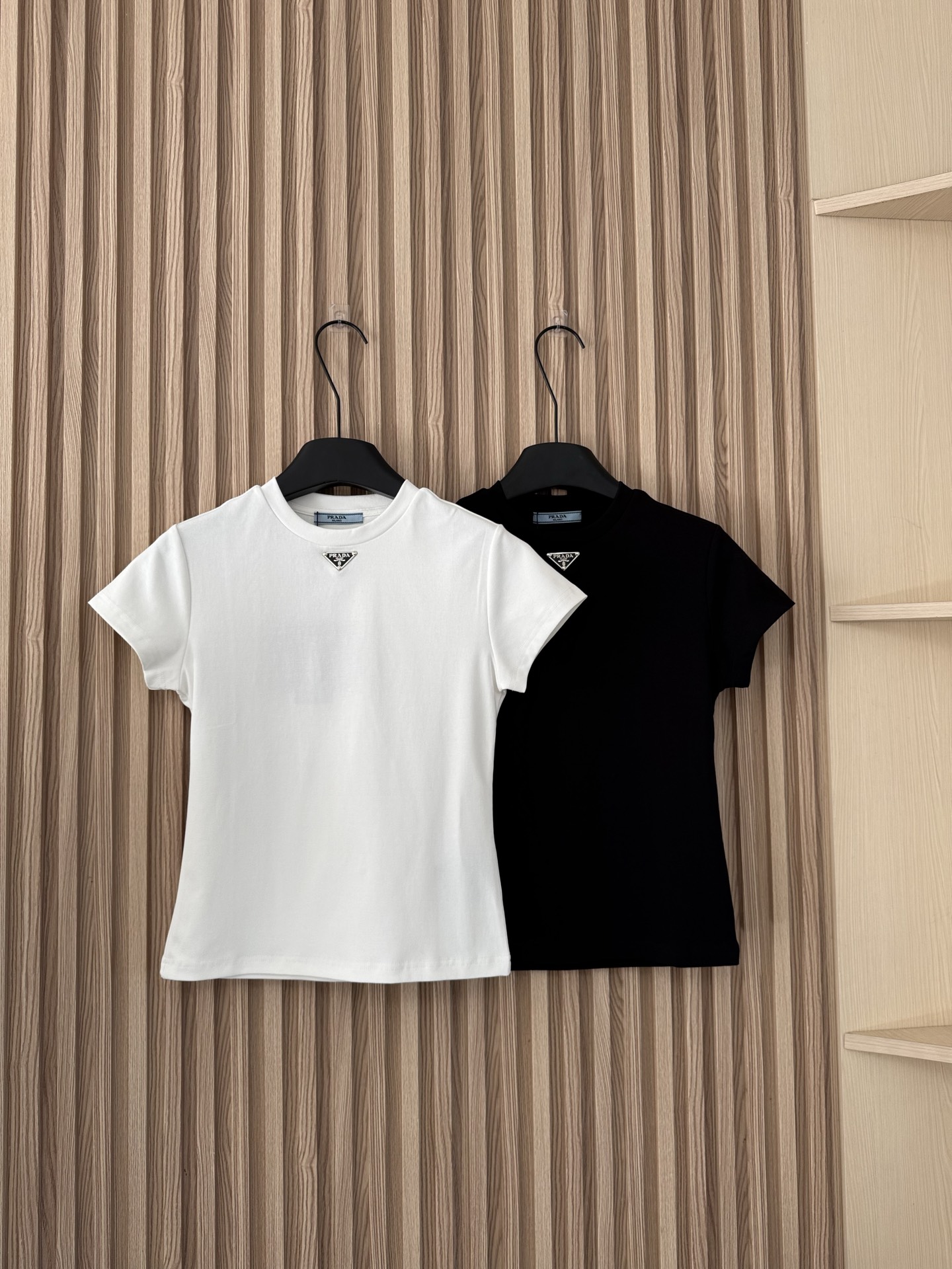 NO:666979,Prada 26 spring and summer new style triangle logo right shoulder waist slimming paper figure elastic short-sleeved T-shirt, the most slimming T-shirt!  The upper body is really invincible, and the pattern design is really, really great. The shoulders are straight and the waist is tucked in. The whole person is tucked in, making it easy to create the effect of a paper man!  Two-color SML,,prada,T-shirt,tees,t-shirt, 19860909Prada 26春夏新款 三角标正肩收腰瘦身纸片人弹力短袖T恤,最显瘦的一款T恤！上身真的无敌了,版型设计真的非常非常赞,正肩收腰版型,整个人都是往里收的,轻松打造纸片人的效果！两色SML,,prada,T-shirt,tees，t-shirt, ,Women's clothing