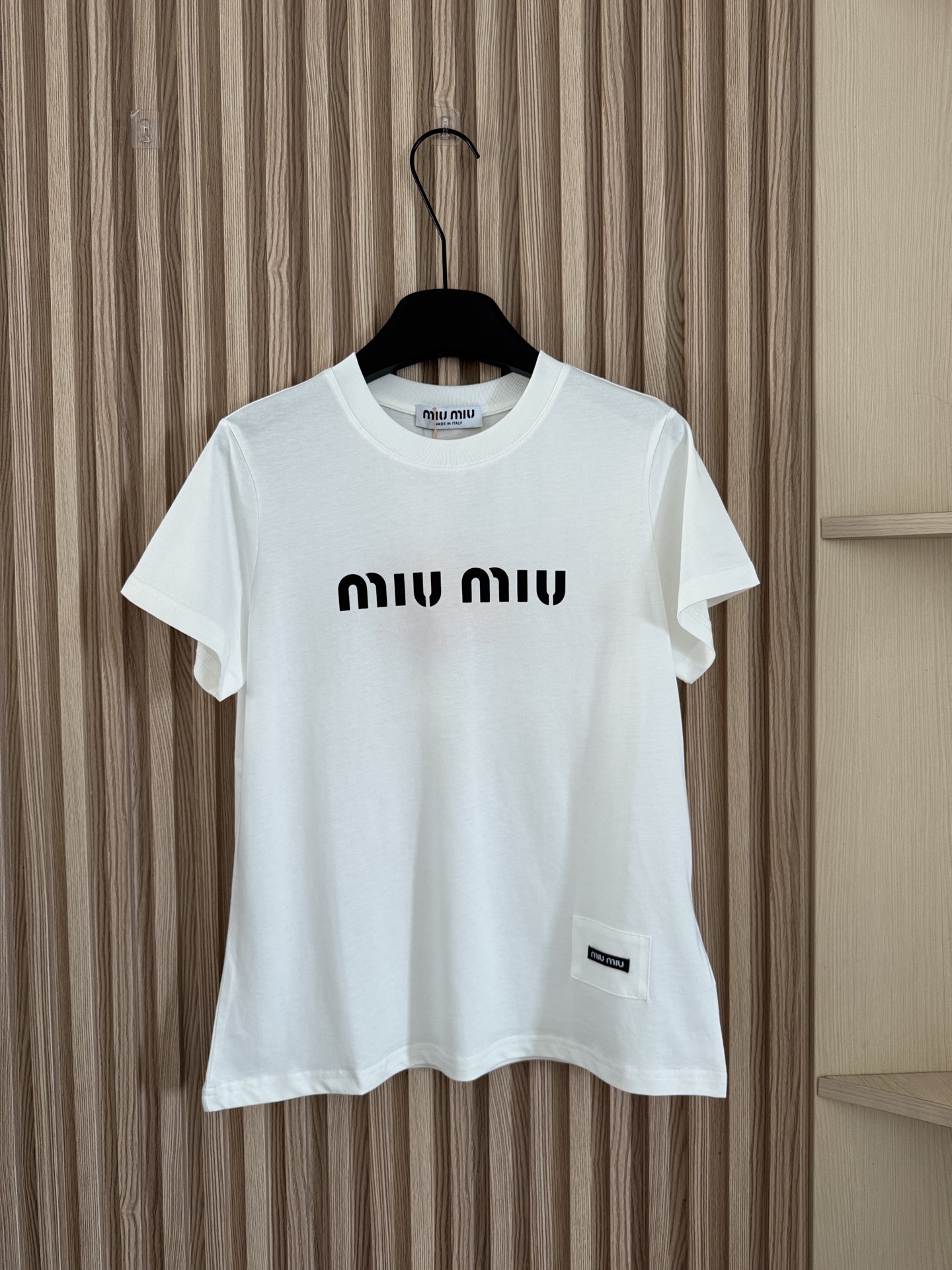 NO:872275,MIUMI* 26 new summer style letter-printed short-sleeved T-shirt shows high-end fashion with minimalist design. The front is printed with highly recognizable capital letters. The font is simple and neat, which perfectly conveys the brand's iconic symbols and easily enhances the recognition of the outfit. It continues the retro sweetheart and French elegance. It can easily create a casual and relaxed daily feel when worn alone. Paired with brand skirts, wide-leg pants or denim items, it can deduce a variety of styles such as sweet and cool, commuting, etc.  Two-color SML,,miumiu,skirts,T-shirt,tees,t-shirt,19860909MIUMI* 26夏季新款 字母印花短袖T恤,以极简设计彰显高阶时尚感,正面采用辨识度极高的大写字母印花,字体简约利落,完美传递品牌标志性符号,轻松强化穿搭辨识度,延续复古甜心与法式优雅气质,单穿能轻松打造随性松弛的日常感,搭配品牌半身裙、阔腿裤或牛仔单品,可演绎出甜酷、通勤等多风格造型 两色SML,,miumiu,skirts,T-shirt,tees，t-shirt,,Women's clothing