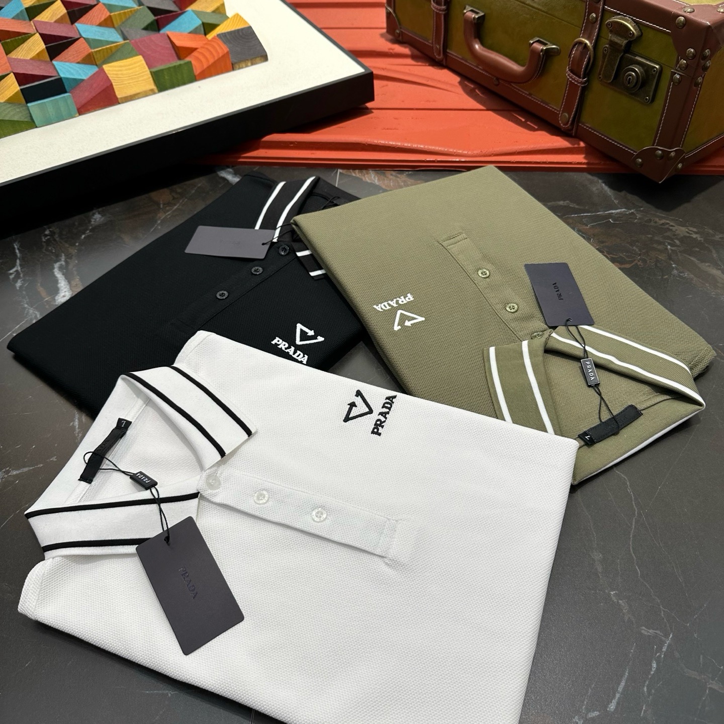 NO:482805,Prada 2025 spring and summer classic Polo collar design, paired with simple single-breasted lines, neat and smooth lines, cleverly modifying the neck lines, showing elegant and gentlemanly style. The exquisite brand logo on the left chest adopts traceless pressing process, delicate and flat, low-key, and luxurious texture, showing the brand's ingenuity and quality pursuit in the subtleties. Selected high-quality fabrics, soft and smooth, breathable, and comfortable and comfortable to wear. Whether it is to wear casual trousers to show professionalism and ability; or to combine them with jeans to create a daily look to create a relaxed and comfortable atmosphere, it can be perfectly adapted. ZZ helps you interpret diverse styles with a calm attitude and show your unique taste. Size M-4XL,,prada,jeans,alexander wang19860909普拉达 2025春夏经典的Polo领设计,搭配简洁的单排扣,线条利落流畅,巧妙修饰颈部线条,彰显优雅绅士格调.左胸处精致的品牌标识,采用无痕压胶工艺,细腻而平整,低调间流露奢华质感,于细微之处展现品牌匠心与品质追求. 精选优质面料,触感柔软顺滑,透气性佳,穿着舒适自在.无论是搭配休闲西裤出席商务场合,展现专业干练；还是与牛仔裤组合打造日常造型,营造轻松惬意氛围,它都能完美适配,ZZ助你以从容姿态诠释多样风格,尽显独特品味. 尺码M-4XL,,prada,jeans,alexander wang,Men's clothing