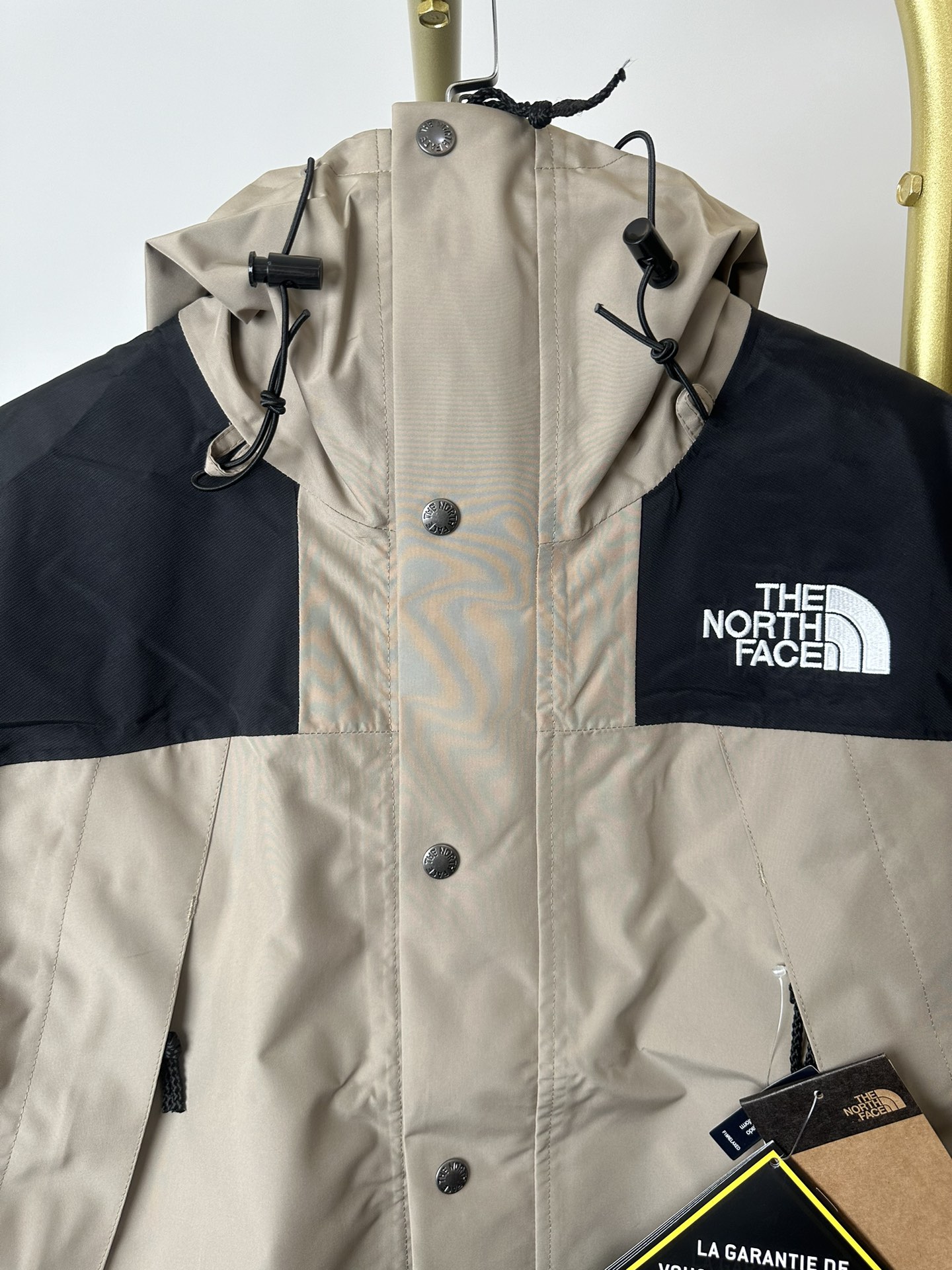 本地() 顶级版本热压THE NORTH FACE/北面 22FW MOUNTAINJACKETGTX 1990冲锋衣(卡其色) 带来90年代的功能性风格 美版1990GTX冲锋衣 距离山顶2KM的时候 脱下保暖内胆和背包 向山顶冲刺 所以起名“冲锋衣” 2L双层GORE-TEX面料 面料表层做强度防水 内层已经覆膜 所以到达实现三层防水的效果 使成衣具有防水透气的出色户外效果 领标附加一张以及袖口刺绣证明GORE-TEX面料身份 内衬冲锋衣面料属于功能性面料 防风防水内里设计 上半部分抓绒内里 下半部分尼龙内里 适用温度18°~零下20° 美版为细绒面的棉布内衬塔夫绸和拉绒经编衬里防风面料 质感厚实穿着舒服 薄薄的单层日版单层穿着感会差很远有点像雨衣般 单层的GTX在外观上也会大打折扣容易皱 拼接上幅拉绒面料设计 下幅尼龙面料设计 腋下有通风拉链的设计户外攀登滑雪越野作业时候实现温度自我控制的目的 田岛刺绣工整立体 饱满度立体感以及每个字母的神韵特点 一笔一划工工整整立体效果强烈 正面+背面+肘部贴片和袖口上的标志性色块和织物阻挡提供了高可见度和增加的耐用性