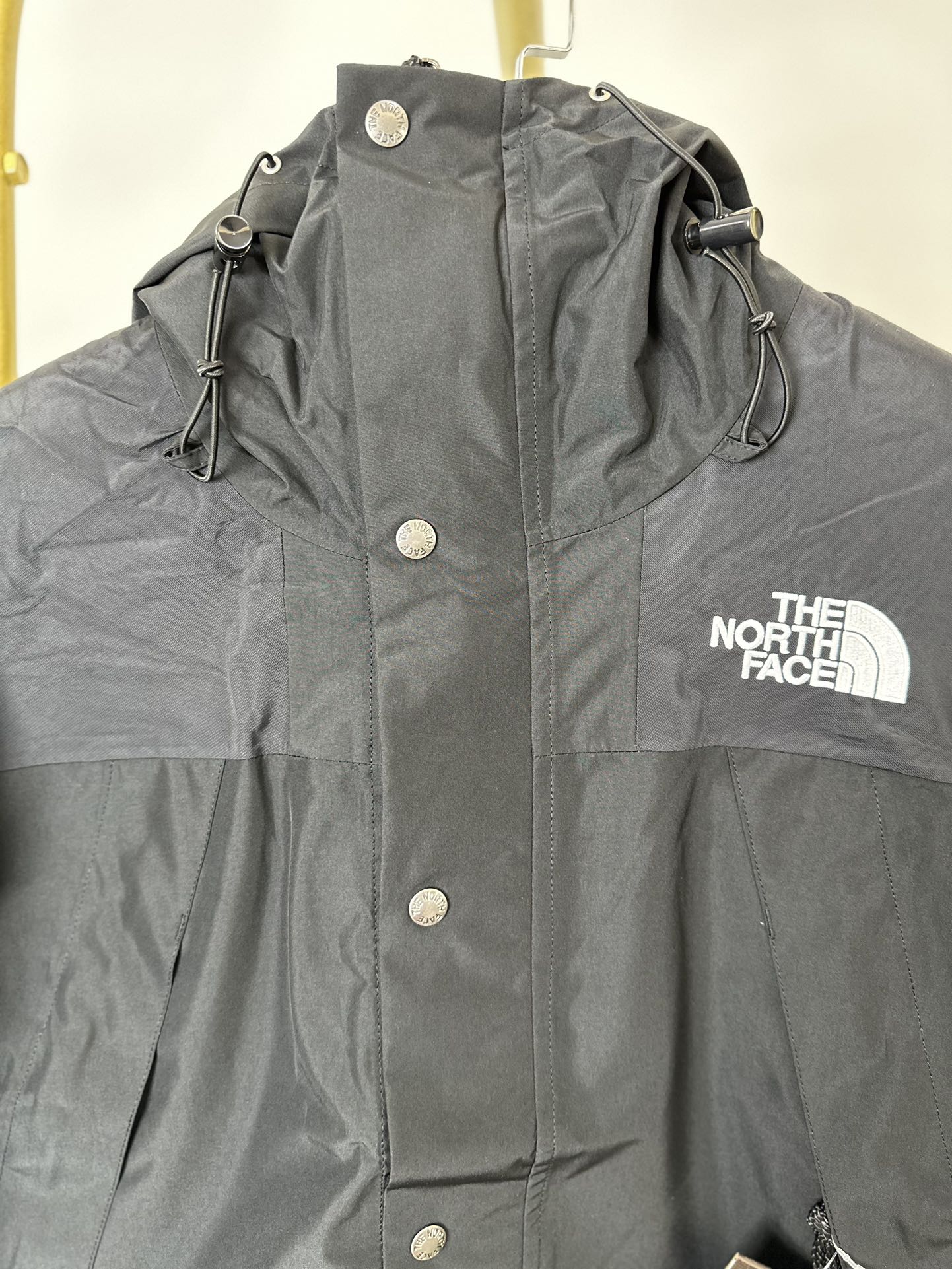 本地() 顶级版本热压THE NORTH FACE/北面 22FW MOUNTAINJACKETGTX 1990冲锋衣(黑色色) 带来90年代的功能性风格 美版1990GTX冲锋衣 距离山顶2KM的时候 脱下保暖内胆和背包 向山顶冲刺 所以起名“冲锋衣” 2L双层GORE-TEX面料 面料表层做强度防水 内层已经覆膜 所以到达实现三层防水的效果 使成衣具有防水透气的出色户外效果 领标附加一张以及袖口刺绣证明GORE-TEX面料身份 内衬冲锋衣面料属于功能性面料 防风防水内里设计 上半部分抓绒内里 下半部分尼龙内里 适用温度18°~零下20° 美版为细绒面的棉布内衬塔夫绸和拉绒经编衬里防风面料 质感厚实穿着舒服 薄薄的单层日版单层穿着感会差很远有点像雨衣般 单层的GTX在外观上也会大打折扣容易皱 拼接上幅拉绒面料设计 下幅尼龙面料设计 腋下有通风拉链的设计户外攀登滑雪越野作业时候实现温度自我控制的目的 田岛刺绣工整立体 饱满度立体感以及每个字母的神韵特点 一笔一划工工整整立体效果强烈 正面+背面+肘部贴片和袖口上的标志性色块和织物阻挡提供了高可见度和增加的耐用性