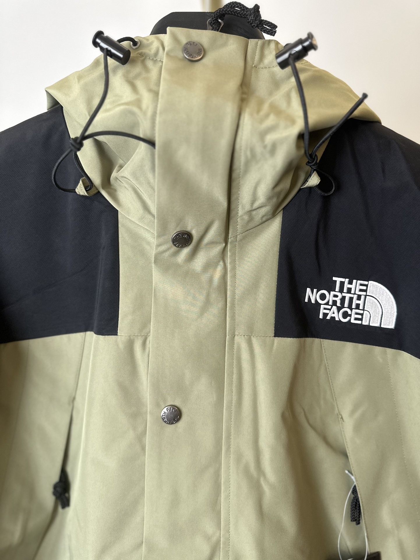 本地 () THE NORTH FACE/北面 22FW MOUNTAINJACKETGTX 1990冲锋衣(豆绿色) 带来90年代的功能性风格 美版1990GTX冲锋衣 距离山顶2KM的时候 脱下保暖内胆和背包 向山顶冲刺 所以起名“冲锋衣” 2L双层GORE-TEX面料 面料表层做强度防水 内层已经覆膜 所以到达实现三层防水的效果 使成衣具有防水透气的出色户外效果 领标附加一张以及袖口刺绣证明GORE-TEX面料身份 内衬冲锋衣面料属于功能性面料 防风防水内里设计 上半部分抓绒内里 下半部分尼龙内里 适用温度18°~零下20° 美版为细绒面的棉布内衬塔夫绸和拉绒经编衬里防风面料 质感厚实穿着舒服 薄薄的单层日版单层穿着感会差很远有点像雨衣般 单层的GTX在外观上也会大打折扣容易皱 拼接上幅拉绒面料设计 下幅尼龙面料设计 腋下有通风拉链的设计户外攀登滑雪越野作业时候实现温度自我控制的目的 田岛刺绣工整立体 饱满度立体感以及每个字母的神韵特点 一笔一划工工整整立体效果强烈 正面+背面+肘部贴片和袖口上的标志性色块和织物阻挡提供了高可见度和增加的耐用性