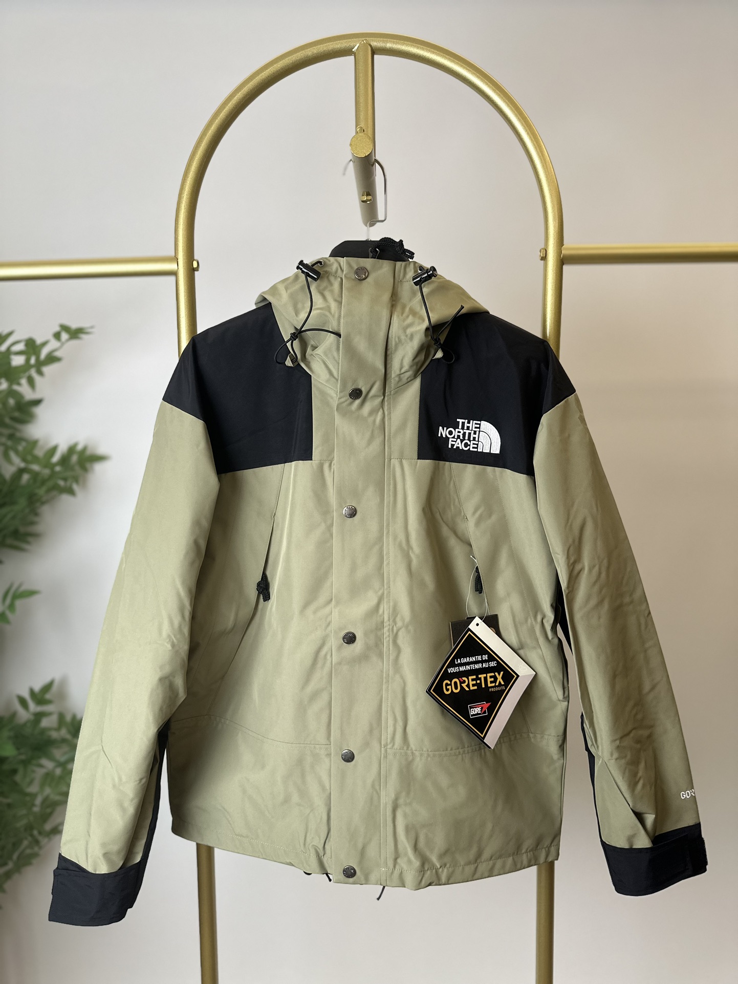 本地 () THE NORTH FACE/北面 22FW MOUNTAINJACKETGTX 1990冲锋衣(豆绿色) 带来90年代的功能性风格 美版1990GTX冲锋衣 距离山顶2KM的时候 脱下保暖内胆和背包 向山顶冲刺 所以起名“冲锋衣” 2L双层GORE-TEX面料 面料表层做强度防水 内层已经覆膜 所以到达实现三层防水的效果 使成衣具有防水透气的出色户外效果 领标附加一张以及袖口刺绣证明GORE-TEX面料身份 内衬冲锋衣面料属于功能性面料 防风防水内里设计 上半部分抓绒内里 下半部分尼龙内里 适用温度18°~零下20° 美版为细绒面的棉布内衬塔夫绸和拉绒经编衬里防风面料 质感厚实穿着舒服 薄薄的单层日版单层穿着感会差很远有点像雨衣般 单层的GTX在外观上也会大打折扣容易皱 拼接上幅拉绒面料设计 下幅尼龙面料设计 腋下有通风拉链的设计户外攀登滑雪越野作业时候实现温度自我控制的目的 田岛刺绣工整立体 饱满度立体感以及每个字母的神韵特点 一笔一划工工整整立体效果强烈 正面+背面+肘部贴片和袖口上的标志性色块和织物阻挡提供了高可见度和增加的耐用性