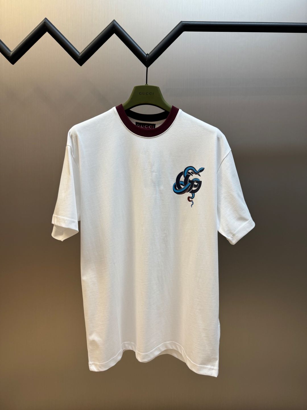 Gucci Camiseta de manga corta con estampado de serpiente y doble G en cuello rojo. Confeccionada en tejido de punto lis…