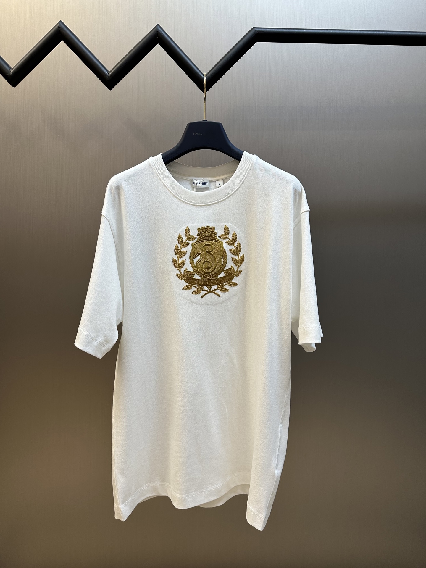 Las mangas cortas con cuello redondo bordado con el logotipo de la hoja de oro de BBR están hechas de tela lisa de algo…