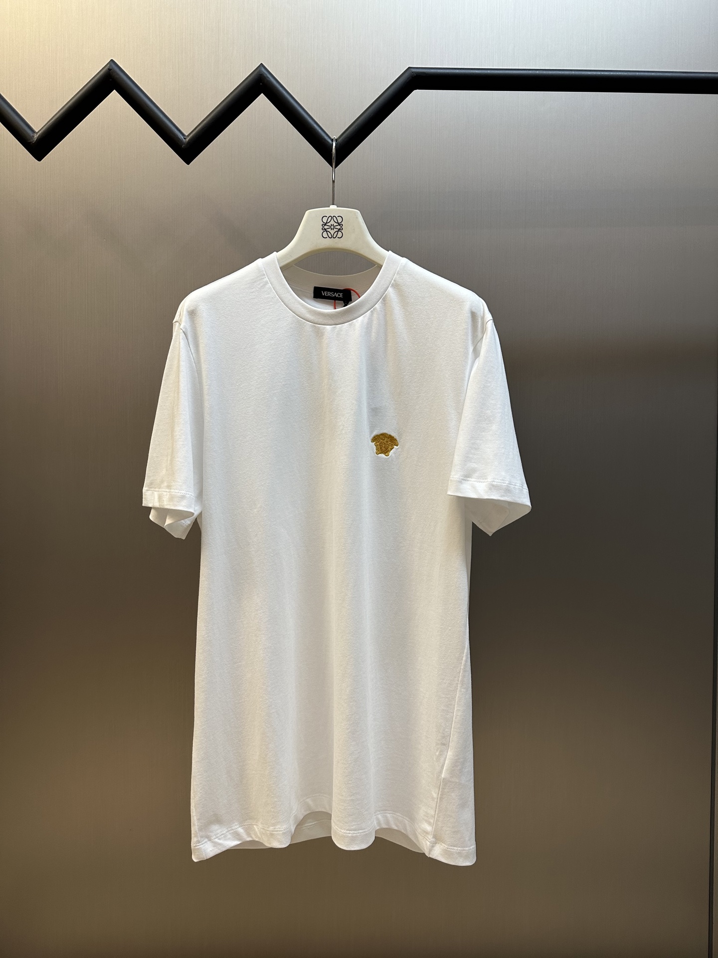 Versace 小金标刺绣短袖 定制雅致温感棉面料，标志性小金标刺绣点缀正面，希腊神话中的蛇妖美杜莎，金色代表着致命的吸引力，增添品牌辨识度，极具视觉冲击力，高级感扑面而来，彰显个性风采。 采用进口机刺绣工艺，使用先进…