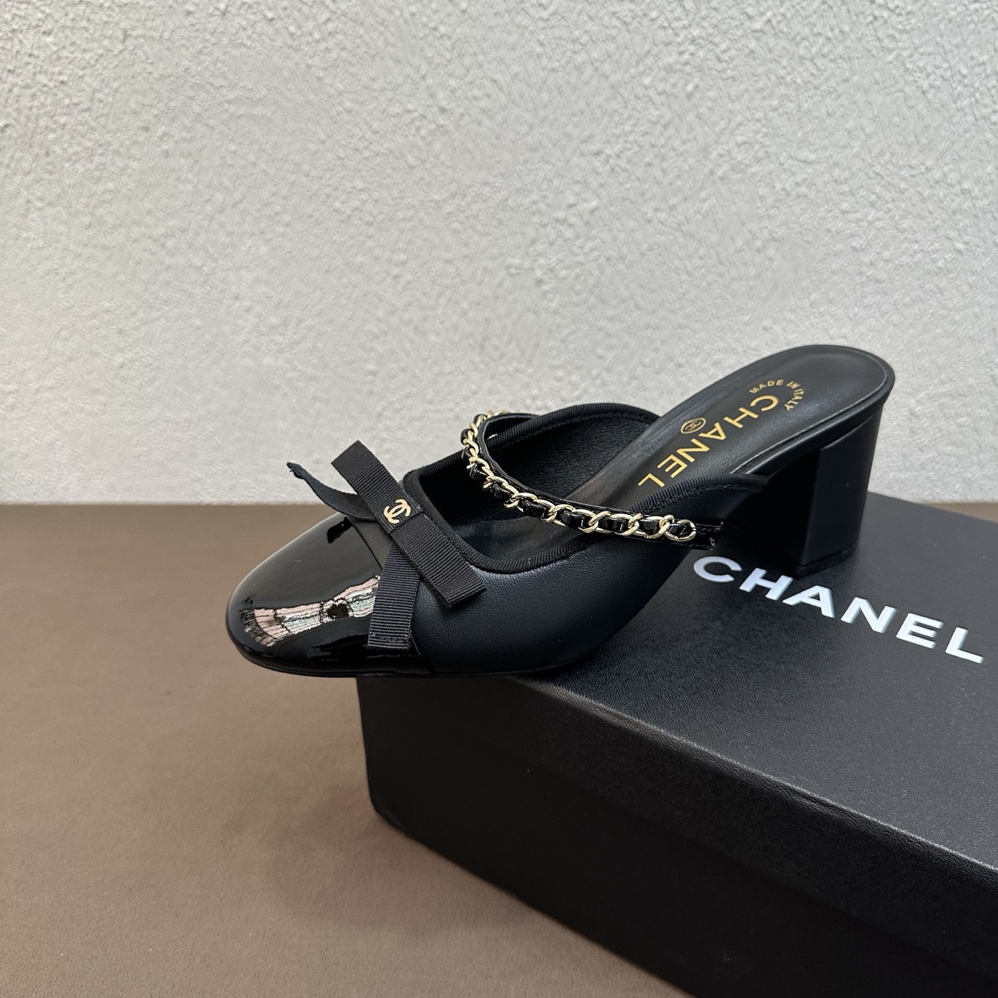 NO:875988,26P Spring and Summer New Style｜Chanel Chanel patent leather color-blocked Mary Jane block heel half-drag, genuine leather large-soled mules, Fengshen retro Mary Jane series makes a strong return, classic black and white color-blocked round toe half-drag, directly filling the sweet and cool atmosphere.  The iconic double C bow decoration on the toe box + metal chain is highly recognizable and has a refined ladylike texture; the patent leather toe box is matched with soft leather, which is heavy-duty and sophisticated, and perfectly captures Xiangjia's classic retro style. The delicate sheepskin material is soft and skin-friendly, and fits the foot shape. The thick heel design combines elegance and walking stability, and is soft and elastic without tiring the feet. It can be worn for commuting, dating, or going out on vacation. It is a practical style for spring and summer.  The upper is made of fine imported lambskin + glossy patent leather. The lining is breathable sheepskin. The sole is original leather outsole. Sizes 35-39 (customized size 40/41). Heel height 6cm, high heels and slippers, chanel, chanel, chanel, mary jane, high heels, slippers, sheepskin, Leather soles.1986090926P春夏新款｜Chanel香奈儿漆皮拼色玛丽珍粗跟半拖 真皮大底穆勒鞋 封神复古玛丽珍系列强势返场 经典黑白拼色圆头半拖,甜酷千金氛围感直接拉满 标志性鞋头双C蝴蝶结饰件+金属链条,辨识度超高,自带精致名媛质感；漆皮鞋头搭配软面皮革,重工考究,把香家经典复古格调完美拿捏. 细腻羊皮材质软糯亲肤,上脚贴合脚型,粗跟设计兼顾优雅气场与行走稳定性,软弹不累脚 通勤、约会、度假出街百搭不挑穿搭,春夏实穿款 鞋面甄选细腻进口小羊皮+亮面漆皮拼接 内里垫脚透气羊皮 鞋底原版真皮大底 码数35–39码（40/41码定制） 跟高6cm,高跟鞋拖鞋,chanel,chanel,chanel,mary jane,high heels,slippers,sheepskin,Leather soles,Women's Shoes