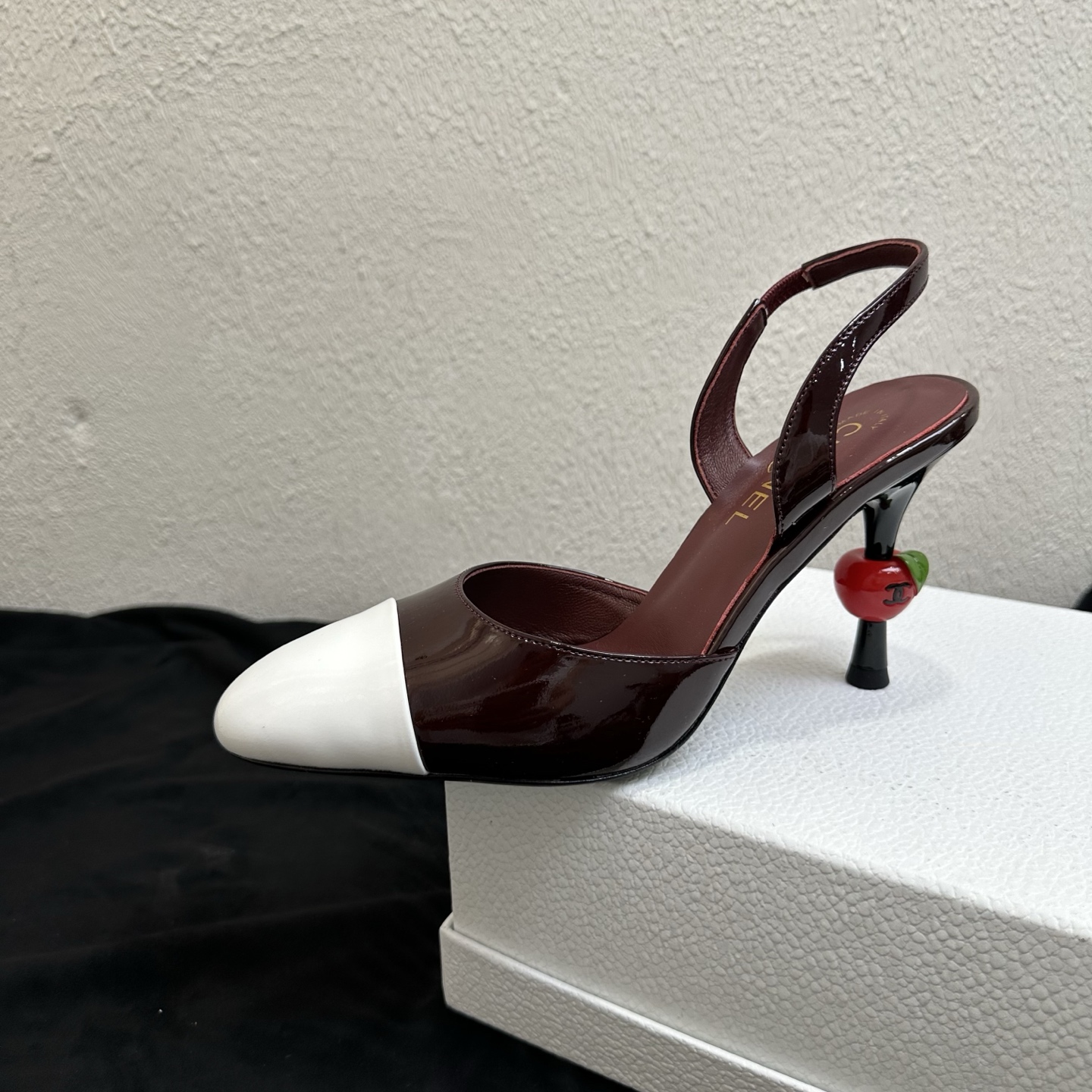 NO:901559,26P Spring and Summer New Style｜Chanel Chanel color-blocked toe-strap high-heeled sandals with cherry heel Fengshen Internet celebrity's hot new style Classic color-blocked round toe back style directly adds to the light luxury atmosphere. Contrast color patent leather toe box + iconic cherry-shaped heel, the design is unique and recognizable, with a French socialite temperament; the elastic back strap is designed to fit the ankle, the version is exquisite and neat, and firmly grasps the light luxury style of Chanel.  The first-layer cowhide material is soft and skin-friendly, and fits the top of the foot. The exquisite stiletto heel elongates the leg line, walking steadily, and is soft and waxy without abrading the feet after long-term wear. It is suitable for commuting to work, dating, outings, and dinner outings. Multiple colors are available. It is a versatile shoe for spring and summer. The upper is imported glossy soft cowhide + glossy patent leather color matching, black, and the lining is imported soft sheepskin. The sole is original genuine leather outsole.  Authentic open molded round toe last, cherry decorated stiletto heel, heel height 9cm, size 35-39 (40/41 size customization is non-returnable), high heels and sandals, chanel, chanel, chanel, sandals, high heels, cowhide, sheepskin, Leather soles1986090926P春夏新款｜Chanel香奈儿拼色包头后带樱桃跟高跟凉鞋 封神网红爆款重磅上新 经典拼色圆头后空款式,轻奢千金氛围感直接拉满 撞色漆皮鞋头+标志性樱桃造型鞋跟,设计独特辨识度拉满,自带法式名媛气质；后绊带松紧设计贴合脚踝,版型精致利落,牢牢拿捏香家轻奢格调. 头层牛皮材质软糯亲肤,上脚贴合脚面,精致细跟拉长腿部线条,走路稳当,久穿软糯不磨脚. 通勤上班、约会出游、晚宴出街全能适配,多色可选,春夏刚需百搭美鞋. 鞋面进口光面软牛皮+亮面漆皮拼色 黑 内里垫脚进口柔软羊皮 鞋底原版真皮大底 正品开模定型圆头楦型,樱桃装饰细跟,跟高9cm 码数35–39码（40/41码定制不退换）,高跟鞋凉鞋,chanel,chanel,chanel,sandals,high heels,cowhide,sheepskin,Leather soles,Women's Shoes