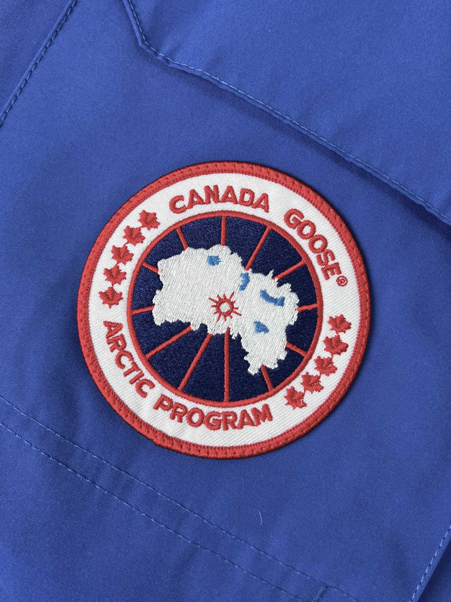 P585💰正品级别 加拿大鹅CANADA GOOES 24新款08款/情侣款远征款派克大衣经典羽绒服  
 大鹅羽绒服：颜色/天蓝色
  尺码：XS. S. M. L. XL. XXL.
   面料：采用台湾进口Y字型魔术贴 ，韩国进口18支涤棉混纺面料，新国标80%广检白鸭绒，加拿大西部郊狼毛，回弹性好，两层内衬，不跑绒，透绒，提供了很高的保暖效果，具备抗污，抗皱，防水和防风的特性，非常耐磨，透气性和舒适性出色。涤棉面料的涤纤维含量高,涤棉面料的耐热耐光性高,稳定性好。颜色鲜艳，纤维强度高，经久耐用、耐光、耐热、挺拔。
   刺绣：直线挺直，曲线圆顺，针迹绵密整齐，边缘无参差现象，绣面平服，丝缕不歪斜，针距一致，不露底，不重叠，绣面光洁，无墨迹等污渍。采用先进的进口绣花机器确保绣花质量。