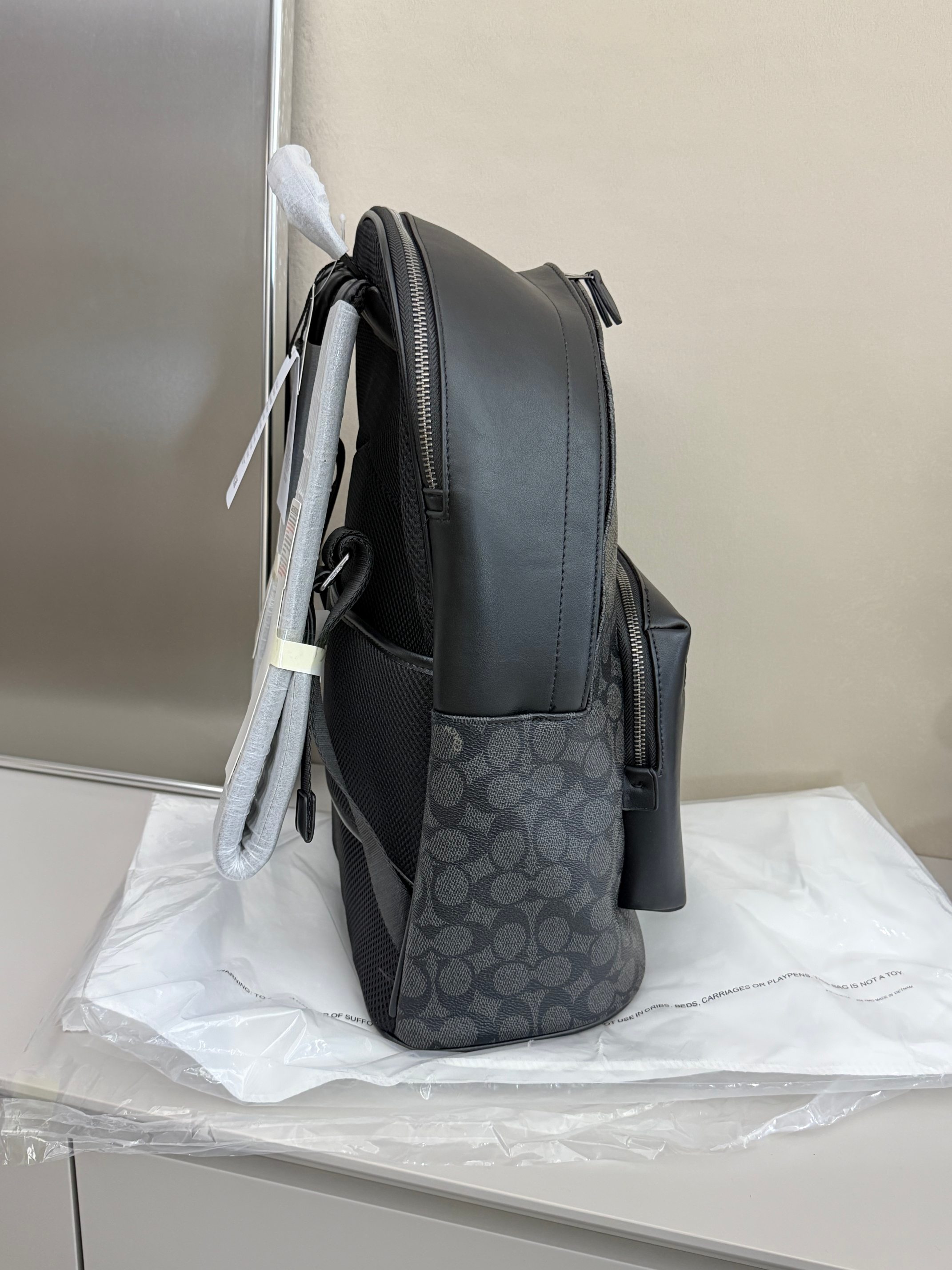 蔻驰男士双肩包尺寸：42×32×15cm简介：黑灰调的型格设计，把都市通勤的利落感焊在身上，经典C纹涂层