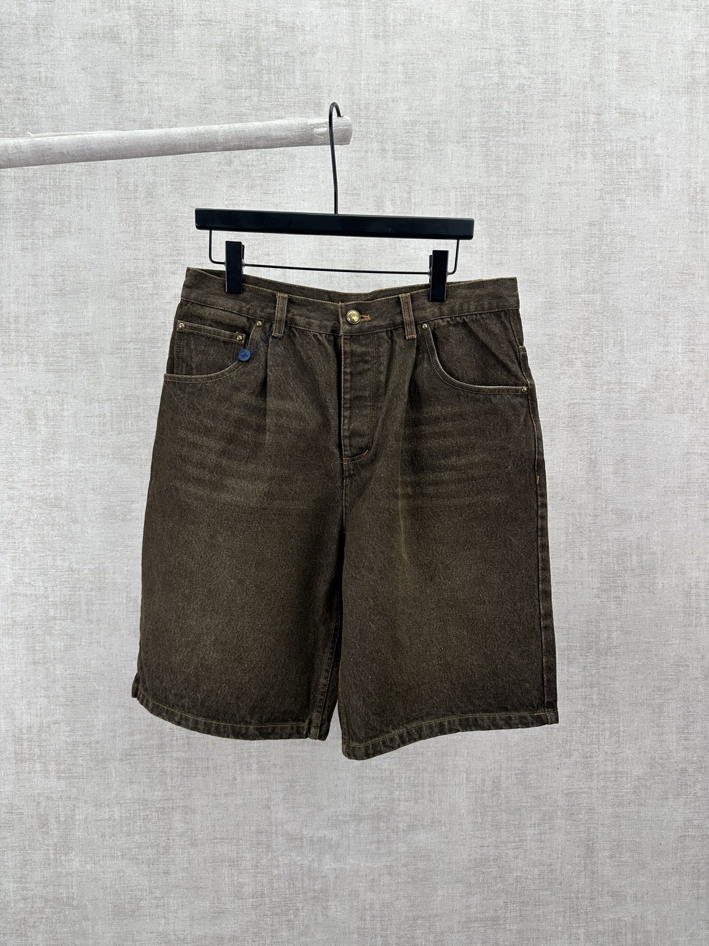 P185 驴家 26ss 新款休闲丹宁滑板短裤采用 2026 年春夏秀场标志性的 Coffee Indigo Denim 面料，经水洗做旧处理。明线、做旧感铆钉及 VVN 皮革腰带环体现品牌制箱工艺传统。后口袋刺绣标识提升造型感，色彩与本…