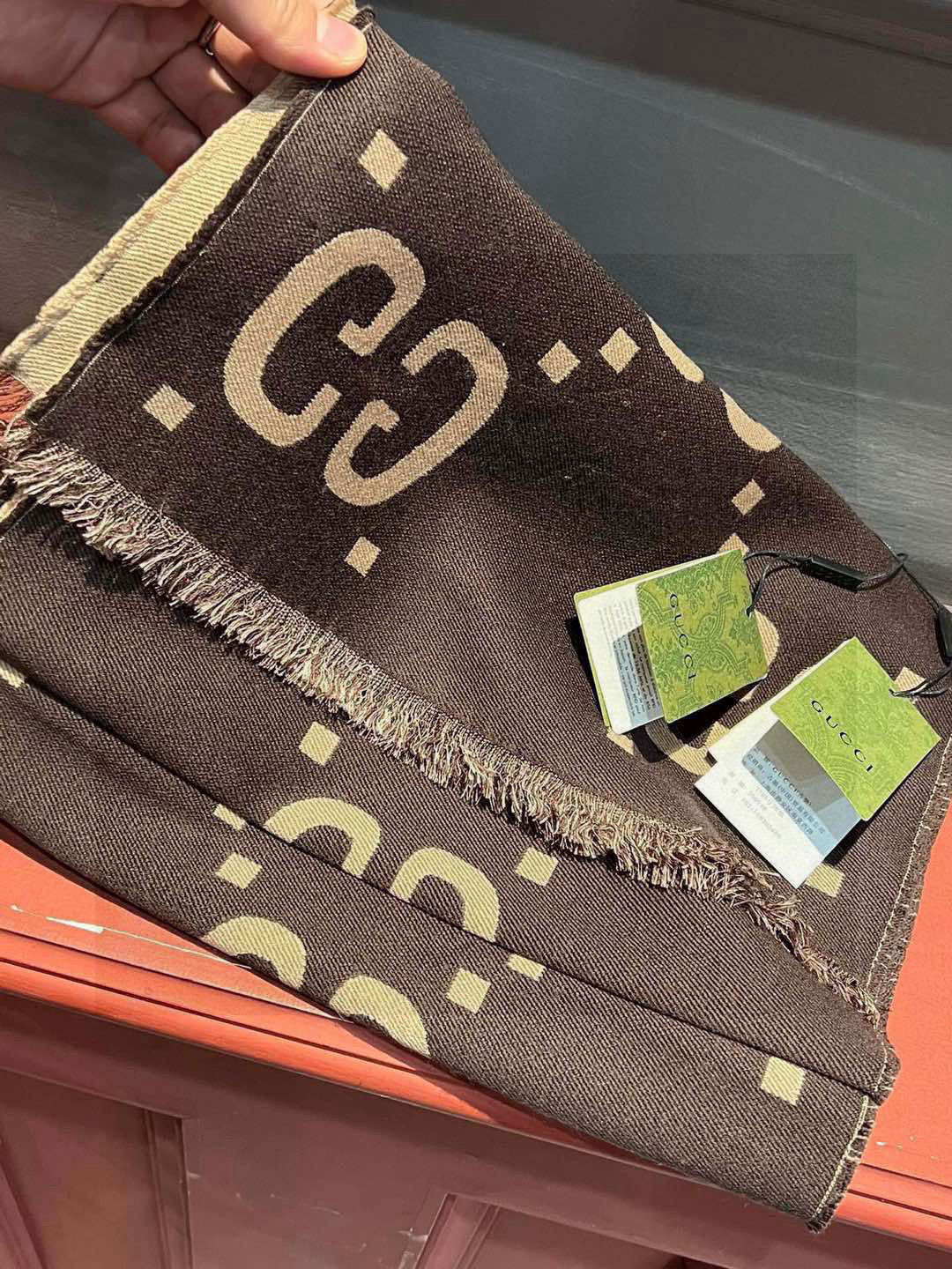   品名   菱形字母 面料：丝羊毛 尺寸：35*190颜色：咖色 
羊毛真丝围巾，装饰超大造型 设计G