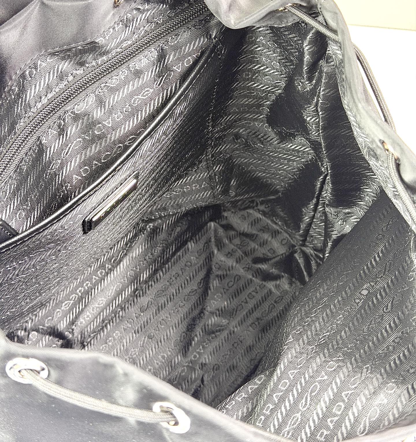 Prada 双肩包🎒采用​​黑色再生尼龙面料​​（Re-Nylon），具有防水、耐磨、抗皱等特性，是Pr