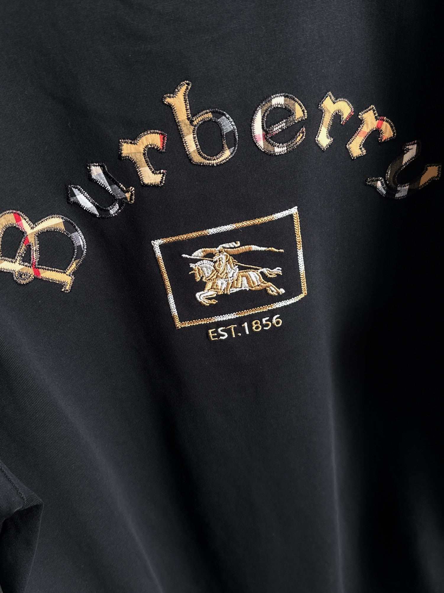 P85

Burberry 巴宝莉 BBR 2026新款 格纹布贴布刺绣战马logo oversize宽松版型 男女同款 短袖t恤
&middot;定制260克100％双纱纯棉面料
&middot;定染32支双股螺纹
&middot;领标吊牌主唛三标齐全
颜色：黑色
尺码：S M L XL