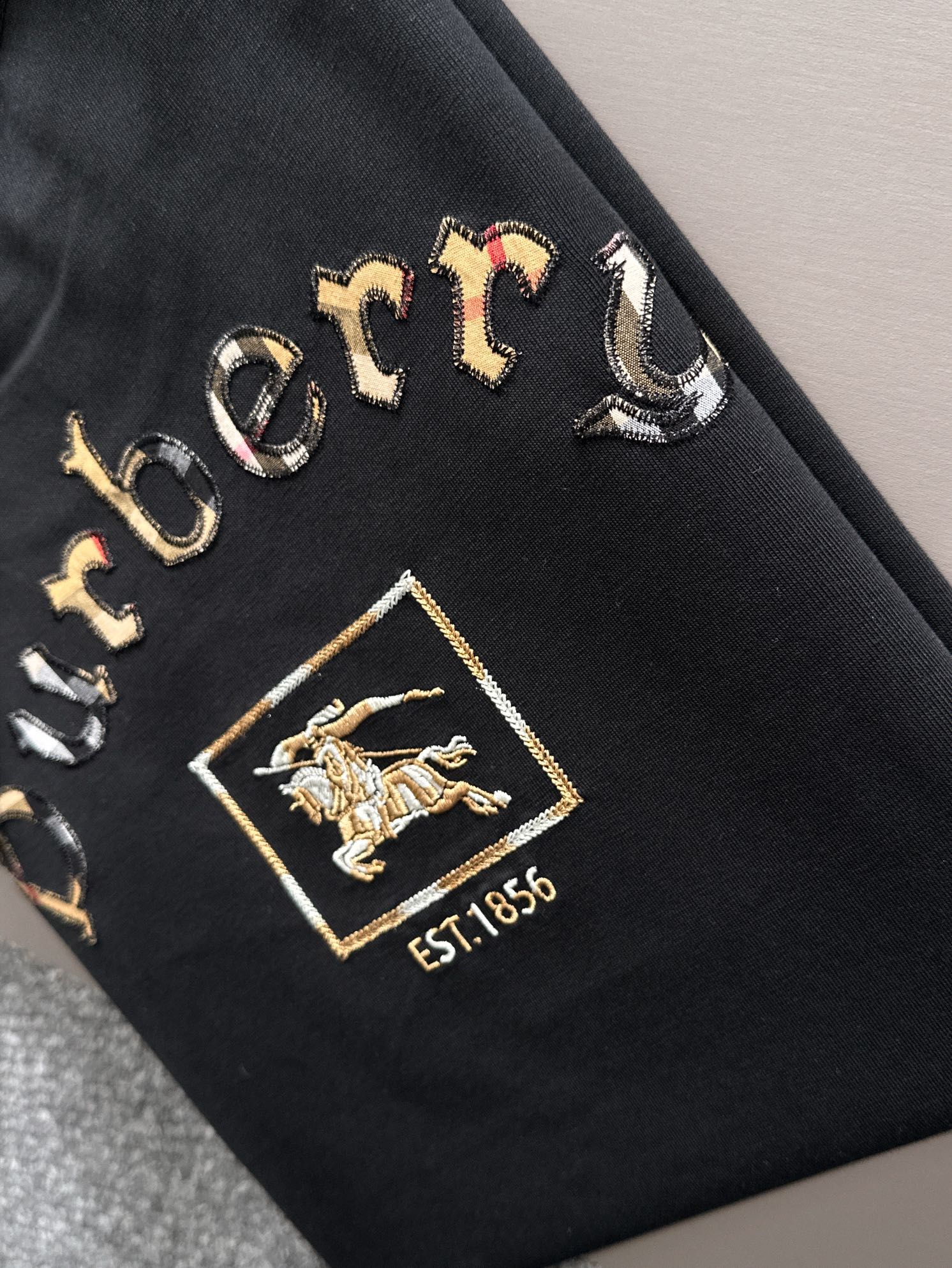 P85

Burberry 巴宝莉 BBR 2026新款 格纹布贴布刺绣战马logo oversize宽松版型 男女同款 短袖t恤
&middot;定制260克100％双纱纯棉面料
&middot;定染32支双股螺纹
&middot;领标吊牌主唛三标齐全
颜色：黑色
尺码：S M L XL