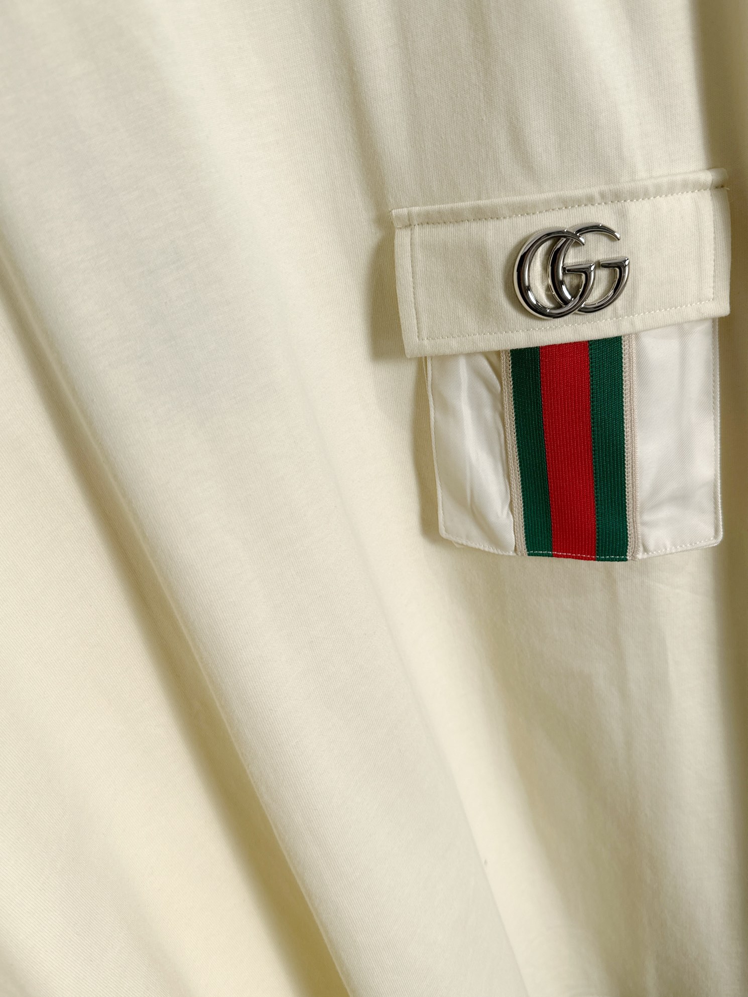 P85 

GUCCI 古驰 2026新款 金属红绿织带拼接口袋 两袖双G字母logo oversize宽松版型 男女同款 短袖t恤
&middot;定制260克100％双纱纯棉面料
&middot;定染32支双股螺纹
&middot;领标吊牌主唛三标齐全
颜色：杏色
尺码：S M L XL