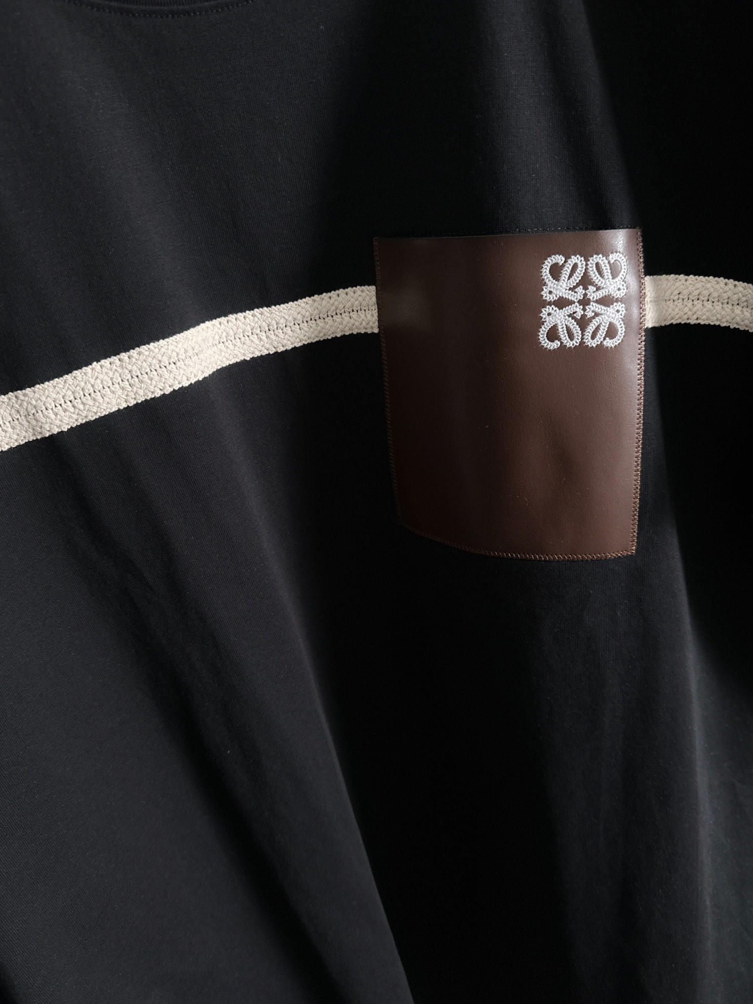 P80

LOEWE 罗意威 2026新款 拼接工艺 定制刺绣logo皮章口袋 男女同款 短袖t恤
&middot;定制260克100％双纱纯棉面料
&middot;定染32支双股螺纹
&middot;领标吊牌主唛三标齐全
颜色：黑色
尺码：S M L XL