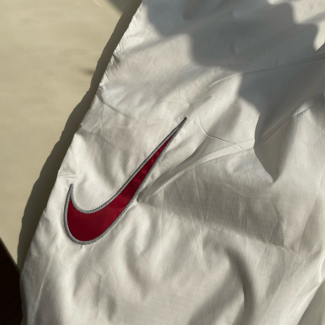 同图不同版，冲🐮货，随意对比 💰265 【反光线版本】Supreme x Nike 联名款SS24 logo宽松半拉链套头夹克外套套装 男女宽松廓版套装
实物质感非常不错 内里网布设计
上身宽松高街范儿 任何身材都能驾驭
渐变色非常有特色 黑色百搭简洁 白色典雅帅气
辅料：全部定制 面料订染 特殊网格 做防水工艺
颜色：黑色 白色 渐变色
尺码： S M L XL （178 150穿M宽松）
S   裤长103     腰围72 臀围 122  
M  裤长105    腰围76  臀围 126
L   裤长107    腰围 80 臀围 130
XL  裤长109  腰围84   臀围 134