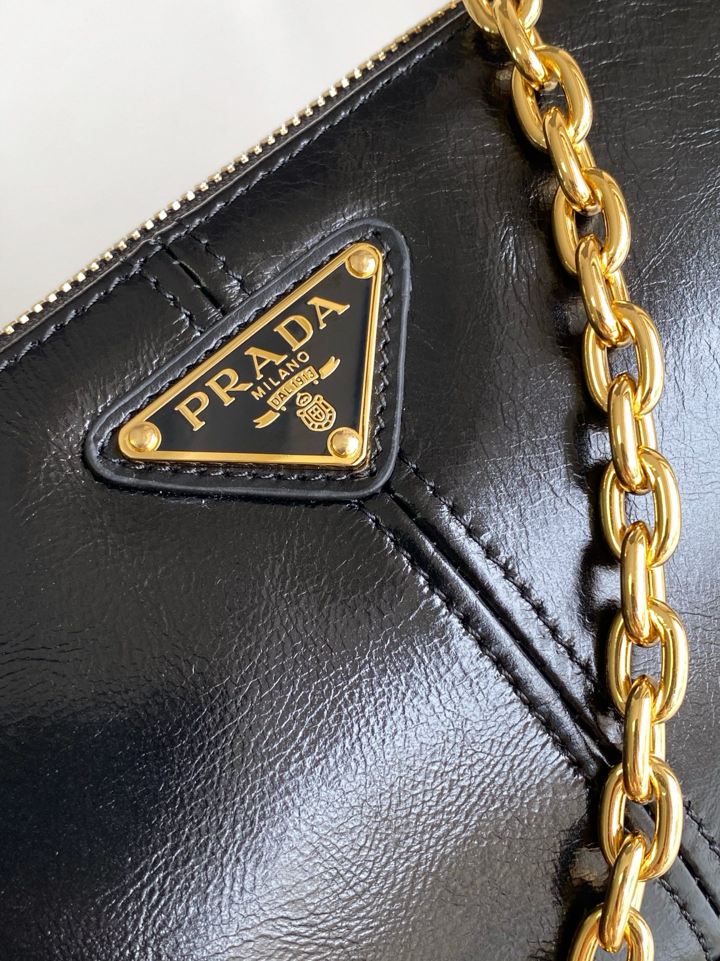 Prada 新款腋下包这款腋下包是2002年 款式的 版 而极简的配饰选用具有 光泽表面的皮革制成
