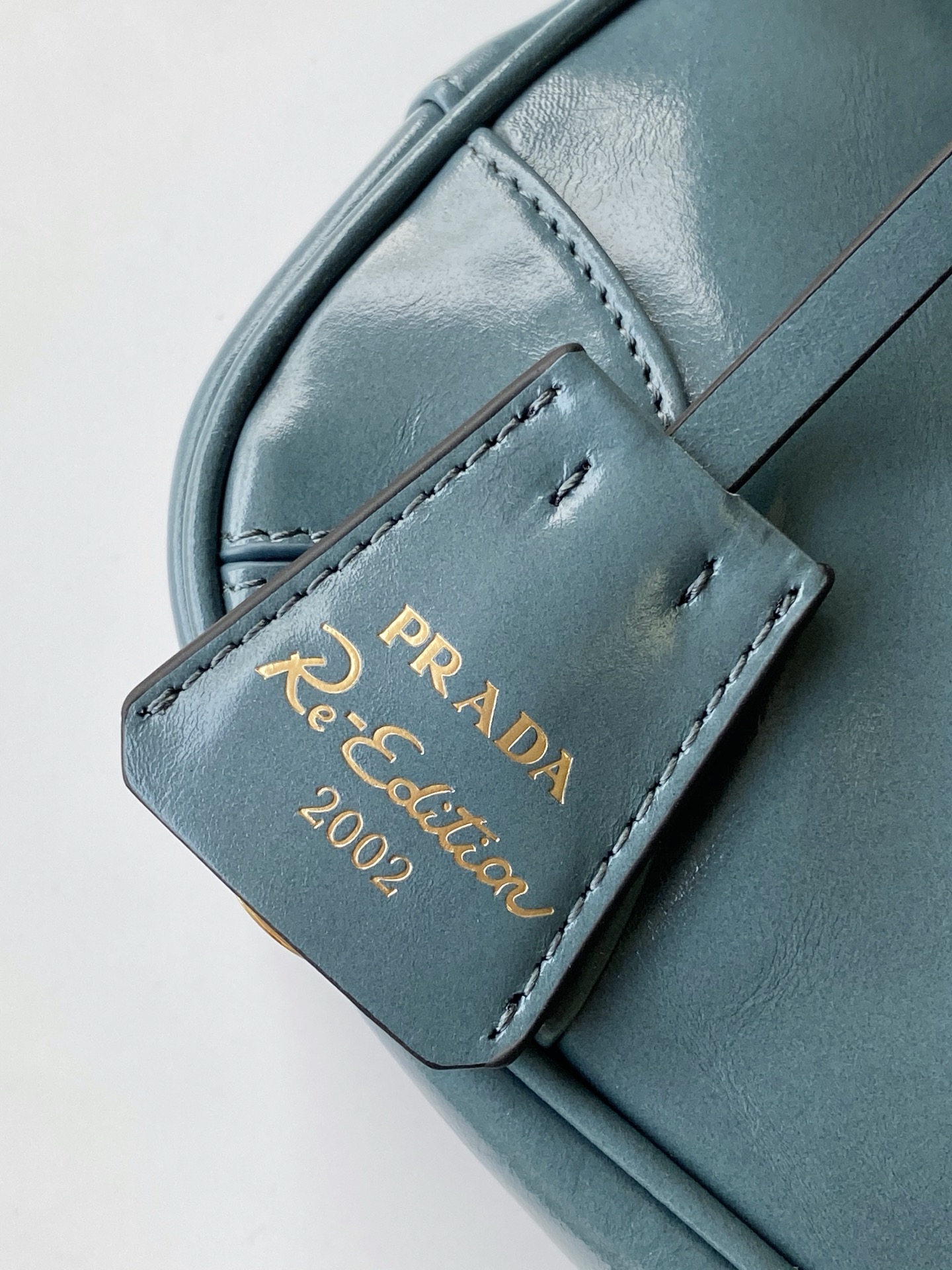 Prada 新款腋下包这款腋下包是2002年 款式的 版 而极简的配饰选用具有 光泽表面的皮革制成