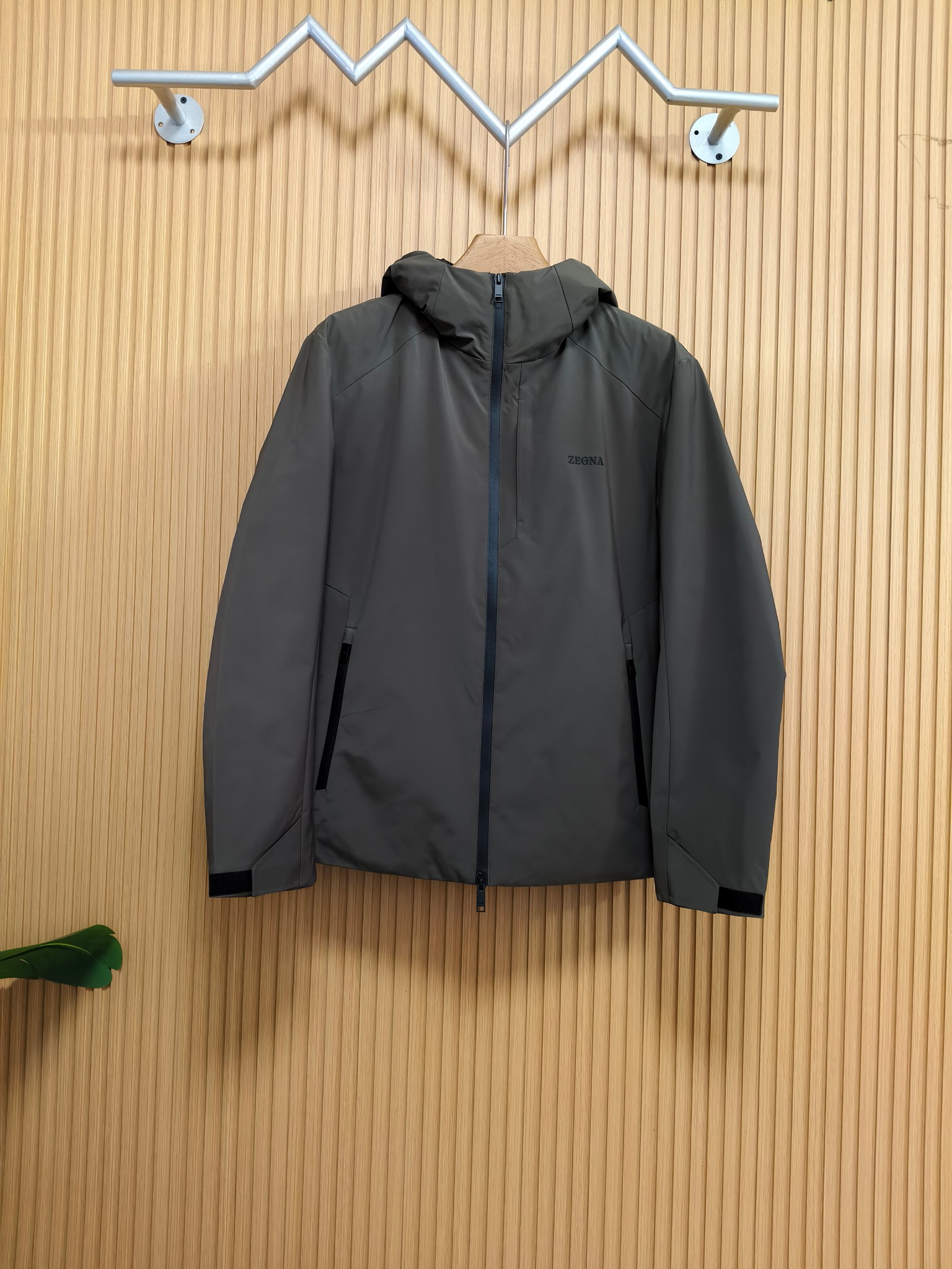 NO:598595,ZEGNA 25 new autumn and winter down jacket ZEGNA's jacket is made of the brand's iconic high-end functional fabric. The fabric is soft and skin-friendly, anti-wrinkle and wear-resistant. It is not easy to deform when worn daily and can still maintain a crisp texture after long-term wear. It can cope with light rain and foggy weather and keep the inside dry.  The brand's hot-glued letters on the chest are just right. The hooded design has a trendy feel, and the drawstring details can be adjusted at will. There is a hidden pocket next to the zipper on the chest, which not only maintains a simple and high-end style, but also adds to the practicality of the jacket. The imported Velcro on the cuffs allows the wearer to freely control the elasticity of the cuffs, relax them for leisure, tighten them for windproof and warm keeping. The overall jacket adopts a slim-fitting micro-profile design, which is based on ergonomics and reserves sufficient space for body activities while retaining the neatness of business attire. Size 48  50 52 54 56 Color black military green,,jackets & coats,down jacket,hats,alexander wang19860909ZEGNA 25秋冬新款羽绒外套  ZEGNA这款外套的面料选用品牌标志性的高端功能性面料,面料柔软亲肤、抗皱耐磨特性,日常穿着不易变形,久穿仍能保持挺括质感；可应对轻雨、多雾天气,守护内里干爽.  衣服胸口的品牌烫胶字母恰到好处.连帽设计自带潮流感,抽绳细节可以随意调节.胸口拉链旁设有隐形口袋,不仅不失简约的高级,还增添了外套的实用性.袖口的进口魔术贴让穿着者可以自由支配袖口松紧,放宽休闲,收紧防风保暖.外套整体采用修身微廓形设计,在贴合人体工学基础上,为身体活动预留充足空间,既保留商务着装的利落感.  码数48 50 52 54 56 颜色黑色 军绿,,jackets & coats,down jacket,hats,alexander wang,Men's clothing