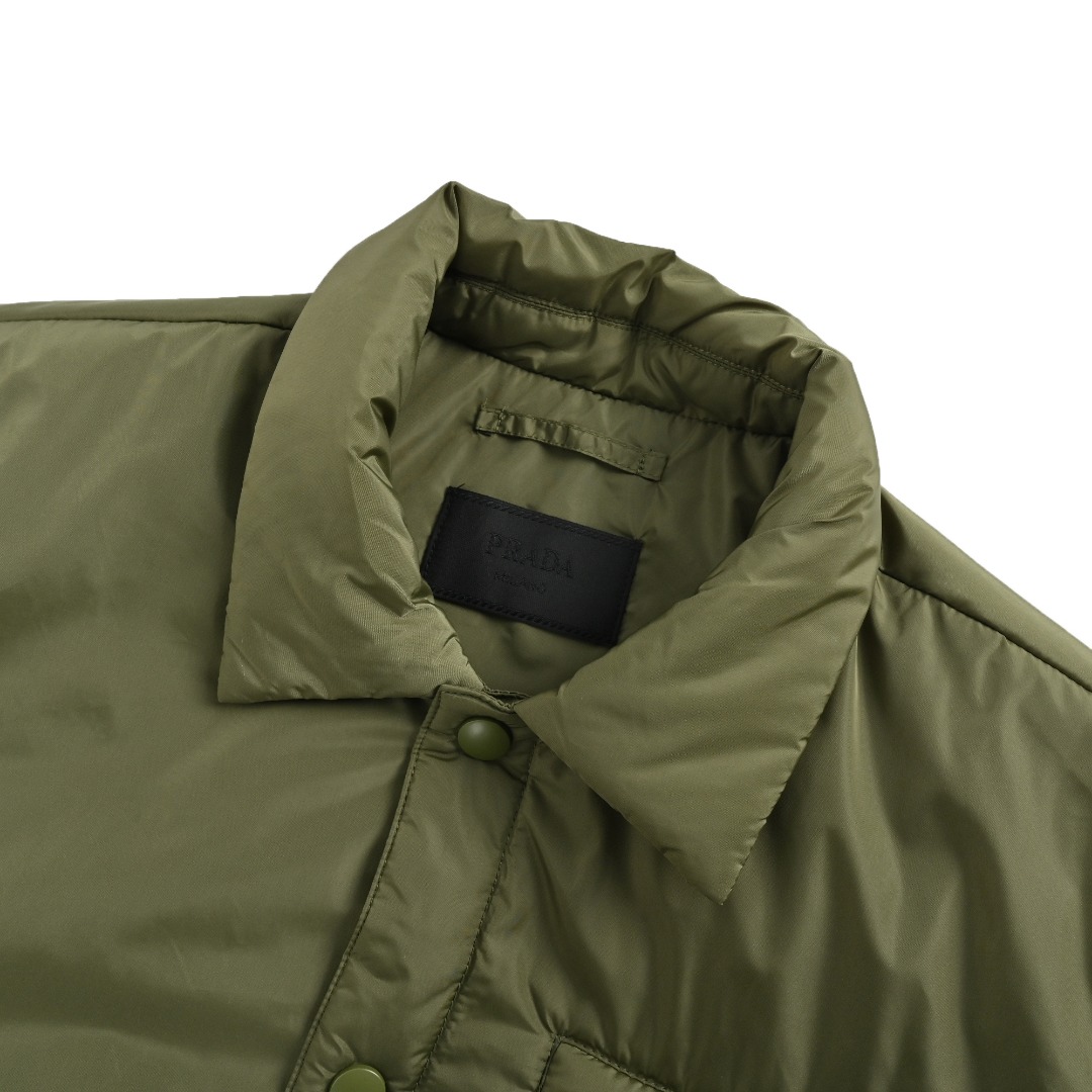 本地自取💰380
 Prada 普拉达 24FW 口袋拉链棉服外套
面料定制高密度尼龙面料，内里充棉克重一致。虽然全幅没有图案Logo，但是我想经典的三角标标识已经够有辨识度了，实物太有质感太舒服了，上身休闲随意的感觉真的非常适合这个季节，随便一搭毛衣或卫衣又非常的酷飒，上身棉服内里加厚，版型Os风格，黑白真的很百搭。进口机器车缝，整体走线拼接处干净整洁，线距密度均匀一致，顶级混穿级别。五金开模全钢电镀，三角标字体精雕配十字纹皮牌，纽扣拉链细节尺寸颜色。
尺码：S-XL