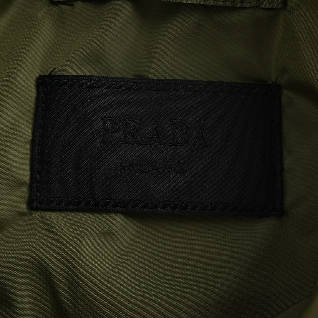 本地自取💰380
 Prada 普拉达 24FW 口袋拉链棉服外套
面料定制高密度尼龙面料，内里充棉克重一致。虽然全幅没有图案Logo，但是我想经典的三角标标识已经够有辨识度了，实物太有质感太舒服了，上身休闲随意的感觉真的非常适合这个季节，随便一搭毛衣或卫衣又非常的酷飒，上身棉服内里加厚，版型Os风格，黑白真的很百搭。进口机器车缝，整体走线拼接处干净整洁，线距密度均匀一致，顶级混穿级别。五金开模全钢电镀，三角标字体精雕配十字纹皮牌，纽扣拉链细节尺寸颜色。
尺码：S-XL