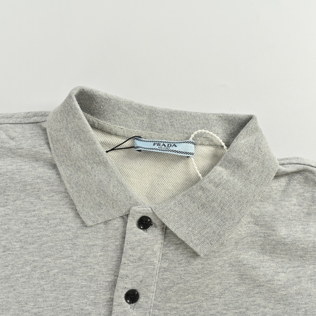 本地自取 💰220
Prada/普拉达 25Fw 毛巾绣logo翻领卫衣
 480克纯棉双纱鱼鳞毛圈面料  
· 面部无尘烧毛工艺 底部吸毛 环保活性染 
· 采用提花刷绣工艺，工艺需线埋底线，后加工填毛工艺，高温烫毛，铲平定位
· 撞色字母微标彰显精致风范
· 纽扣采用天然树胶材料
· 螺纹针织衣领，袖口，底边
· 双针车线跨缝工艺
· 原版主唛水洗吊牌防潮纸包装
   颜色：灰色/黑色
Size:S-XL