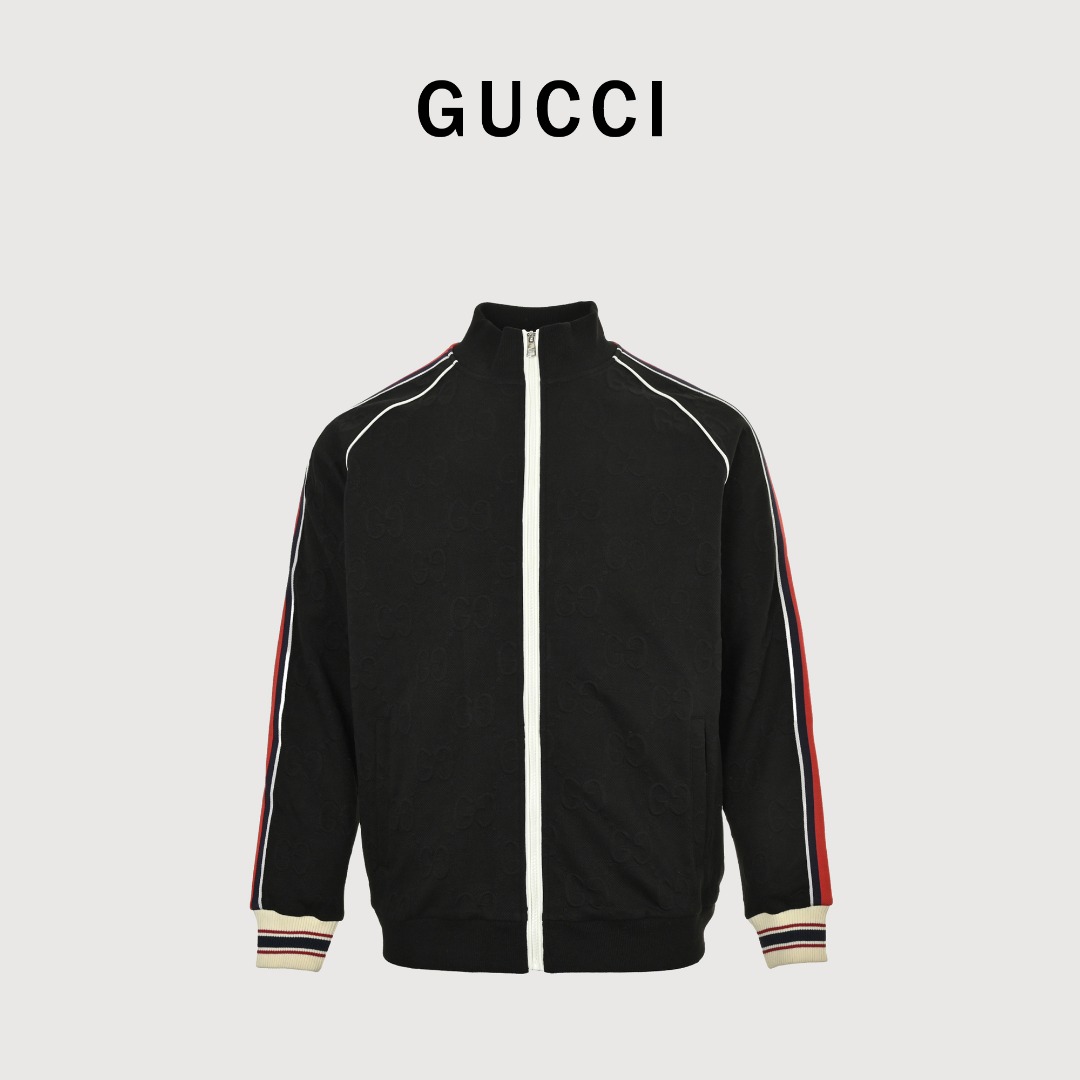 Gucci/古驰 25Fw 全幅双G提花红绿条织带套装外套 采用订织100%聚酯仟维双面提花面料,耗时近一个月,面料柔软细腻光滑, 做工完全遵循ZP工艺,门襟拉链左右暗纹完全对位,整体以深绿色为主色调, 给人沉稳、低调的感觉.衣袖与裤侧加入了红、白、蓝三色条纹, 红色与蓝色的撞色搭配十分亮眼,为整套服装增添了活力与时尚感, 同时也展现了Gucci独特的设计美学.卫衣领口处的白色拉链, 搭配带有Gucci标识的拉链头,精致且彰显品牌细节.袖口和裤脚处采用了罗纹收口设计, 且罗纹上带有红、白、蓝三色条纹装饰,不仅贴合身体,还增强了服装的整体设计感. 采用立领拉链款式,可自由调节领口开合度,方便穿脱,同时立领设计也增添了几分利落感. 衣服正面设有两个对称的口袋,兼具实用性与美观性,方便放置一些小物件. 搭配同款长裤更佳! 颜色:黑色,墨绿色