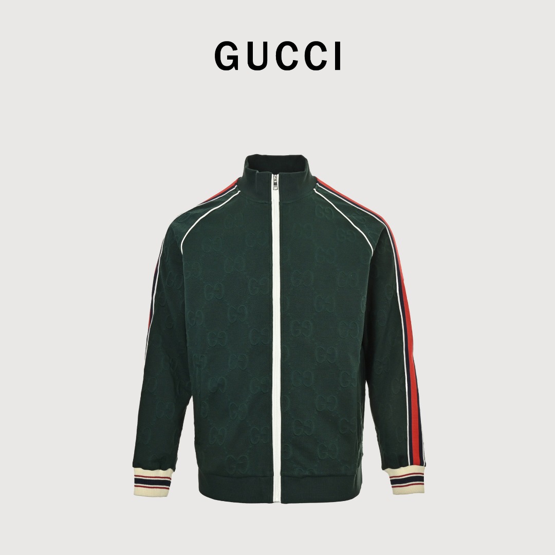 Gucci/古驰 25Fw 全幅双G提花红绿条织带套装外套 采用订织100%聚酯仟维双面提花面料,耗时近一个月,面料柔软细腻光滑, 做工完全遵循ZP工艺,门襟拉链左右暗纹完全对位,整体以深绿色为主色调, 给人沉稳、低调的感觉.衣袖与裤侧加入了红、白、蓝三色条纹, 红色与蓝色的撞色搭配十分亮眼,为整套服装增添了活力与时尚感, 同时也展现了Gucci独特的设计美学.卫衣领口处的白色拉链, 搭配带有Gucci标识的拉链头,精致且彰显品牌细节.袖口和裤脚处采用了罗纹收口设计, 且罗纹上带有红、白、蓝三色条纹装饰,不仅贴合身体,还增强了服装的整体设计感. 采用立领拉链款式,可自由调节领口开合度,方便穿脱,同时立领设计也增添了几分利落感. 衣服正面设有两个对称的口袋,兼具实用性与美观性,方便放置一些小物件. 搭配同款长裤更佳! 颜色:黑色,墨绿色