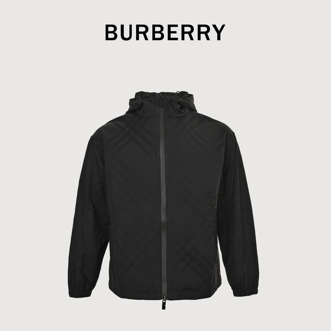 本地自取💰380 Burberry 巴宝莉 BBR25ss战马斜纹格连帽夹克 面料采用锦纶为基底打造的一款耐用性极强的面料（尼龙）。密度仅1.14g/CM³，使其同等厚度下重量减轻20%。同时耐磨性极强，反复摩擦不易起毛。大量运动之后其疏水纤维形成毛细效应，引导汗液快速蒸发。通过提综装置控制经纱分成，电子提花机电磁针以0.01秒每针速度控制，使纬纱在特定位置与经纱交织，形成预设的斜格暗纹。采用CAD制版系统预设实体绣区域和激光区域，通过绣花机1000rpm针速形成达8798针高精度战马刺绣。再使用激光切割工艺，在绣花边缘区域精准移除底布面料，±0.1mm的激光精度使绣体平滑无毛边。 Size:S-M-L-XL