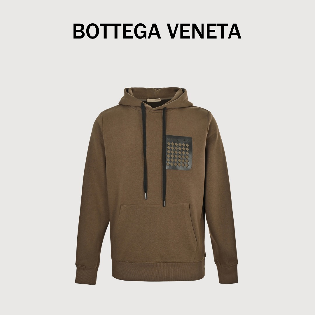 BOTTEGA VENETA/BV 口袋编织连帽卫衣 BV新款连帽卫衣,以重磅棉绒打造宽松立体廓形 连帽设计搭配抽绳 轻松提升街头感,超大立体斜插口袋设计,兼顾随手插兜的率性姿态与随身物件的安全感.胸前口袋藏着一片立体的intrecciato编织宇宙. 高精准激光切割琢出精密菱形图腾,采用传统技法,每英寸需经16次手工交叉穿引,确保真皮织物既能保持挺括形态又具备弹性张力以最经典的BV菱形纯手工编织而成的口袋,真正的奢侈,是把复杂工艺穿得举重若轻