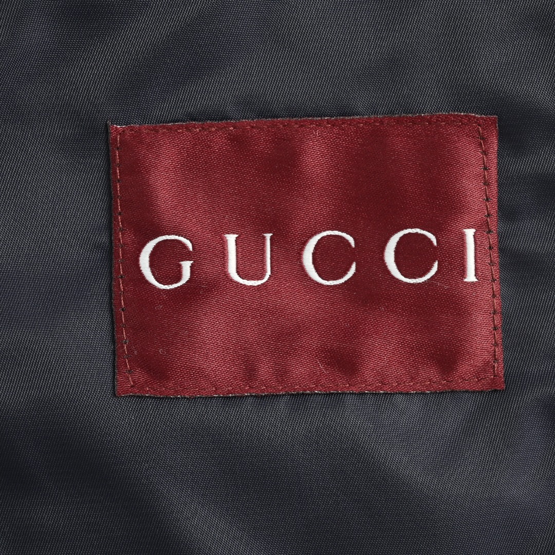 GUCCI古驰GUC 斜纹尼龙防风领连帽外套 选用100%锦纶纤维紧密编织而成的蓝色密织斜纹尼龙面料.经纬纱线之间的空隙非常小,表面呈现清晰的45度角斜向纹理.锦纶突出的耐磨性,抗拉扯等优点使成衣增加使用寿命.较小的密度强化防风性,同时兼具一定的防水性能,在室外能更好的发挥其功能性. LOGO刺绣贴饰采用0.3毫米超细聚酯绣线,经激光切割定型工艺打造浮雕质感.每片贴饰经过5道抗皱处理,确保水洗后仍保持原有形态. False Two-Piece设计增添层次感和独特性,采用高端隐形暗扣将帽子部分和大身链接一体,独立完整的双层结构,单穿叠穿皆宜.定制辅料