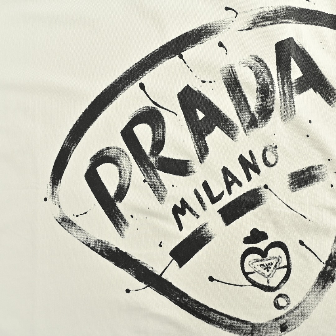 Prada/普拉达 25Fw 大logo徽标泼墨印花长袖T恤 P家情侣款长袖T恤 渠道精品推荐,基础百搭的简约款短袖TEE 早秋最新款,男生女生四季通勤装! 客供定织300g高克重双纱棉布料子 肉实的质感, 一眼可见的高级 贵气 贴身柔软舒适,挺括的面料 超级正的版型裁剪 让你上身时尚大气又不失时髦感 大logo徽标泼墨印花, 宽松OVERSIZE版型,适合当下潮流风格的穿搭 男生女生都能轻松驾驭. 颜色:黑色, 白色