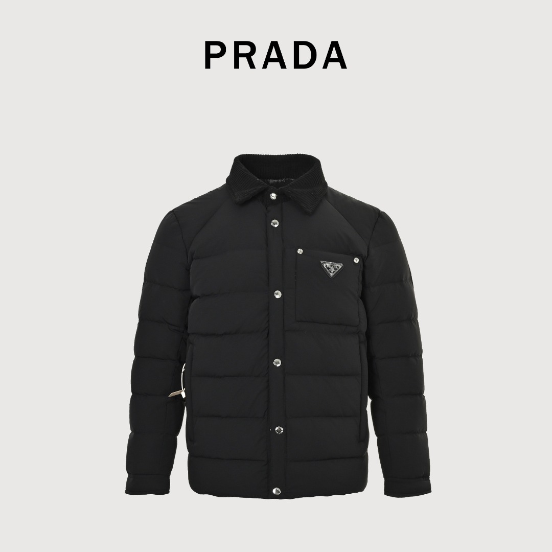 Prada/普拉达 25FW 新款轻薄胸前刚标 立领男女同款羽绒服 这是一件Prada(普拉达)2025秋冬新款男士防风翻领羽绒服,具有以下特点: • 品牌与设计辨识度:胸前的珐琅涂层经典三角标口袋是Prada的标志性元素,灯芯绒翻领与羽绒衣身形成材质对比,展现品牌一贯的轻奢调性. • 面料与保暖性:采用客供进口的锦纶氨纶混纺面料,兼具防风拒水性能;内里填充90%白鹅绒,保暖且不显臃肿,实现“风度与温度并存”. • 细节工艺:配备客供定制的银色立体刻印Logo金属纽扣,细节处彰显高品位;休闲直筒剪裁,适配日常、休闲乃至部分正式场合的穿搭需求. • 风格定位:属于奢侈品牌的高定风格单品,融合了功能性与时尚设计,是追求简约摩登、低调奢感男士的优选.