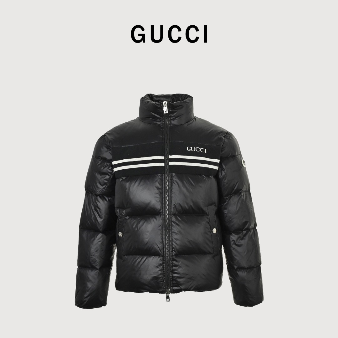 本地自取💰𝟔𝟔𝟎
古驰 立领条纹羽绒服
古驰 胸前logo条纹 男女同款羽绒服

𝐒𝐢𝐳𝐞:𝟒𝟐 𝟒𝟒 𝟒𝟔 𝟒𝟖 𝟓𝟎
	•	版型：属于短款立领羽绒服，版型较为宽松，能够营造出休闲且具时尚感的穿搭风格，对身材的包容性较好，适合多种身形的人群驾驭。

	•	色彩：主体采用深蓝色，这种颜色沉稳大气，同时带有一定的光泽感，提升了整体的高级感；中间的黑色织带搭配白色条纹，形成经典的撞色设计，增强了视觉层次感。

材质分析

	•	面料采用高光泽的尼龙材质，这种材质具有良好的防水、防风性能，同时质感挺括，能让羽绒服保持饱满的廓形，且易于清洁和打理。

	•	填充物应为高品质鸭绒或鹅绒，从蓬松度来看，保暖性能优异，能够在寒冷的季节为穿着者提供充足的温暖。

设计细节

	•	品牌标识：正面醒目的“GU**i”白色字母刺绣，以及袖子上的品牌标志性双G元素圆形徽章，强化了品牌辨识度，是品牌身份的直观体现。

	•	拼接设计：胸前的黑色织带与白色条纹拼接，打破了纯色面料的单调感，同时织带的材质与羽绒面料形成对比，增加了设计的丰富度。

	•	功能性设计：立领设计可有效阻挡寒风；双向拉链方便穿脱和调节保暖度；两侧的口袋带有金属扣装饰，既具有实用性，又提升了细节处的精致感。