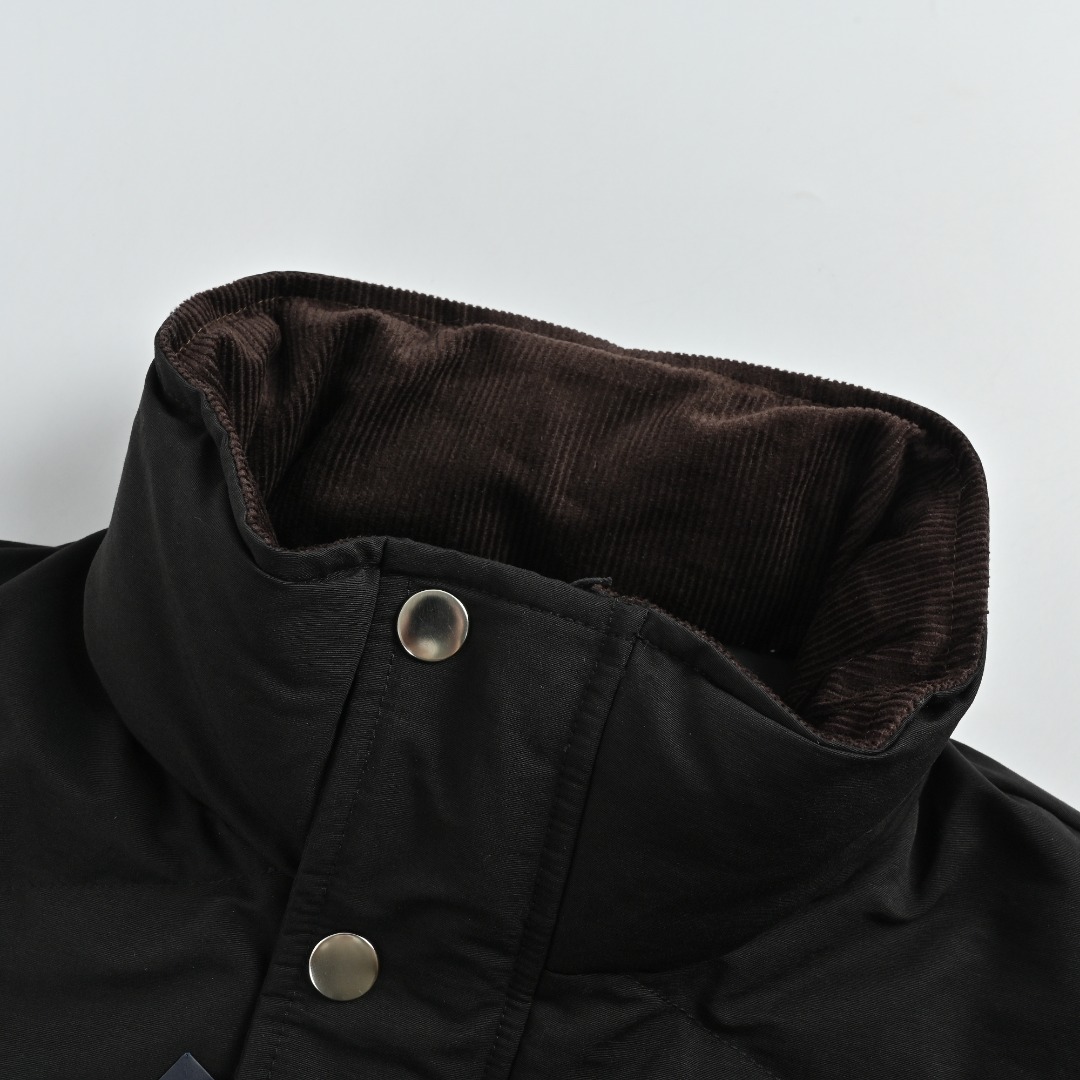 本地自取 💰580 Prada/普拉达 25Fw 三角标立领绗缝羽绒服 PRADA饰三角标立领羽绒夹克，甄选高支府绸面料，经纱细密、纬纱粗韧的高密编织造就独特哑光十字肌理，兼具棉质亲肤与尼龙挺括质感；内填230g 90精选白鸭绒，蓬松回弹且轻盈保暖。创新采用65度斜线绗缝工艺，分区独立线迹赋予面料充足形变空间，不易绷紧断裂，菱形网格更添现代高级动感；袖口与下摆搭配弹力罗纹设计，柔软贴合锁温无束缚，辅以一比一定制三角标、拉链头及纽扣，尽显品质细节。 Size:46-52