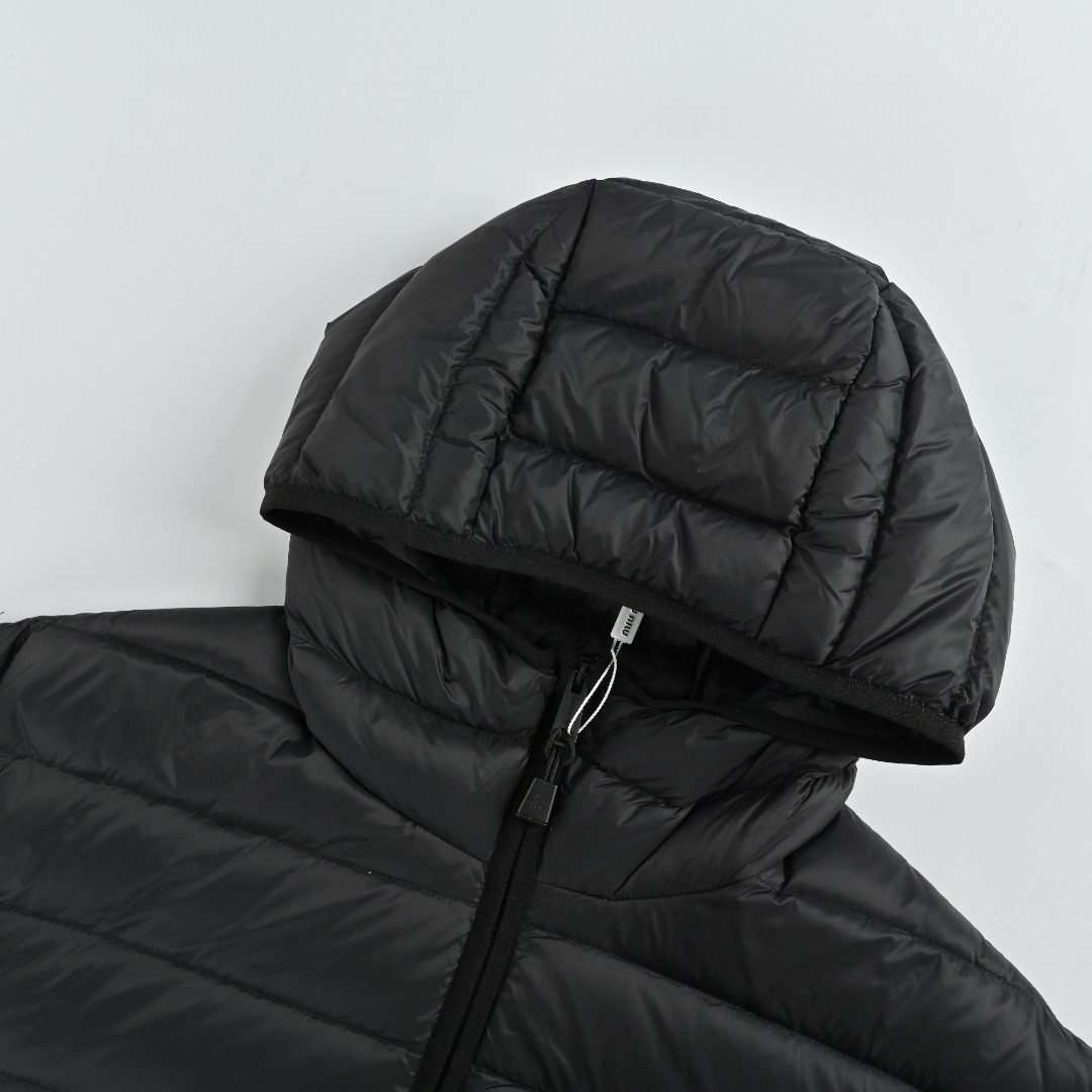 本地自取💰520 MIU MIU缪缪MM 字母刺绣连帽羽绒服 选用高支数的聚酰胺纤维打造的高端尼龙面料,以出色的抗拉强度和耐磨性能著称,其良好柔韧性使面料不易起皱,长久保持挺括有型。紧密的织法有效阻挡冷风侵袭,锁住羽绒层产生的暖空气。高密度尼龙表面形成一定的荷叶效应,小水滴不易渗透,保持内部干爽,有效提升羽绒使用寿命。 采用90国标高品质羽绒,充绒量达到了180克,蓬松度高、保暖性强,轻盈无负担,轻松应对寒冷天气。无论是都市通勤还是户外休闲,这件连帽羽绒服皆以出色性能和简约设计,成为冬季衣橱中不可或缺的单品 1、徽标采用进口机刺绣工艺,使用先进的计算机控制系统和精密的机械部件,实现mimiu刺绣作业,精度高、线条流畅且细腻。 2、选用进口7号针+防绒细线绗缝,每三公分达13针,线迹顺直,不跳针。 3、拉链的两侧被配套的面料包裹缝合,使得从正面和侧面看,几乎看不到拉链的齿和链带,包边不是到领口就停止,而是继续向上,只能看到一条连贯、平整的缝合线。实现完美的防风连续性,更创造了流畅,高级的线条感。 Size:46 48 50 52