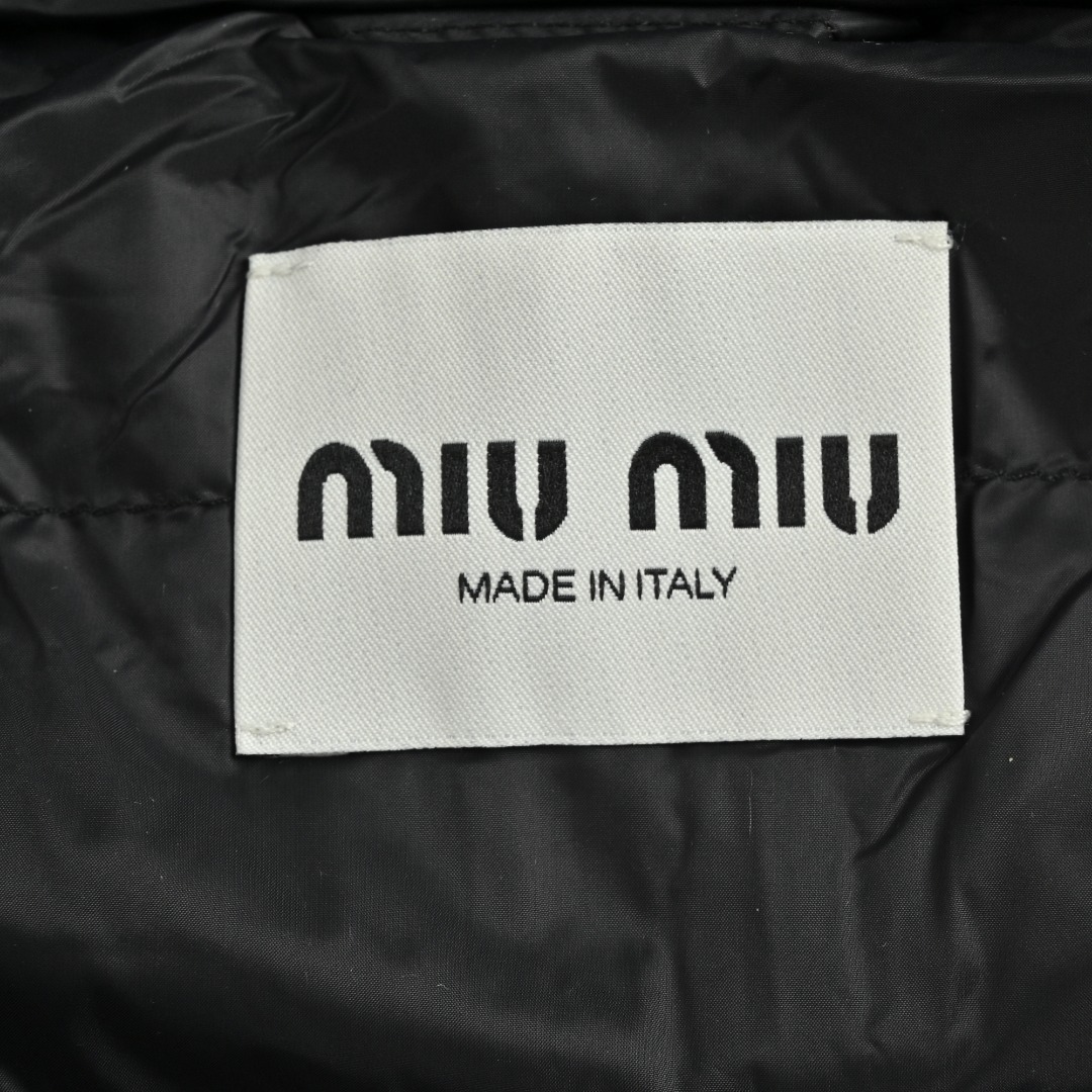 本地自取💰520 MIU MIU缪缪MM 字母刺绣连帽羽绒服 选用高支数的聚酰胺纤维打造的高端尼龙面料,以出色的抗拉强度和耐磨性能著称,其良好柔韧性使面料不易起皱,长久保持挺括有型。紧密的织法有效阻挡冷风侵袭,锁住羽绒层产生的暖空气。高密度尼龙表面形成一定的荷叶效应,小水滴不易渗透,保持内部干爽,有效提升羽绒使用寿命。 采用90国标高品质羽绒,充绒量达到了180克,蓬松度高、保暖性强,轻盈无负担,轻松应对寒冷天气。无论是都市通勤还是户外休闲,这件连帽羽绒服皆以出色性能和简约设计,成为冬季衣橱中不可或缺的单品 1、徽标采用进口机刺绣工艺,使用先进的计算机控制系统和精密的机械部件,实现mimiu刺绣作业,精度高、线条流畅且细腻。 2、选用进口7号针+防绒细线绗缝,每三公分达13针,线迹顺直,不跳针。 3、拉链的两侧被配套的面料包裹缝合,使得从正面和侧面看,几乎看不到拉链的齿和链带,包边不是到领口就停止,而是继续向上,只能看到一条连贯、平整的缝合线。实现完美的防风连续性,更创造了流畅,高级的线条感。 Size:46 48 50 52