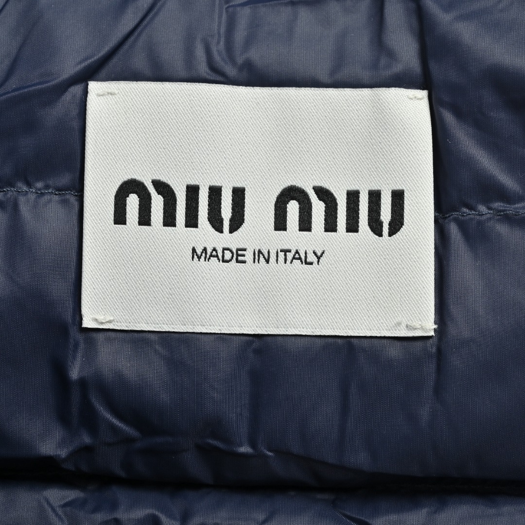 本地自取💰380 MIU MIU缪缪MM 字母绣排骨羽绒马甲 选用高支数的聚酰胺纤维打造的高端尼龙面料,以出色的抗拉强度和耐磨性能著称,其良好柔韧性使面料不易起皱,长久保持挺括有型。紧密的织法有效阻挡冷风侵袭,锁住羽绒层产生的暖空气。高密度尼龙表面形成一定的荷叶效应,小水滴不易渗透,保持内部干爽,有效提升羽绒使用寿命。 采用90国标高品质羽绒,充绒量达到了140克,蓬松度高、保暖性强,轻盈无负担,轻松应对寒冷天气。 徽标采用进口机刺绣工艺,使用先进的计算机控制系统和精密的机械部件,实现mimiu刺绣作业,精度高、线条流畅且细腻。 Size:46 48 50 52