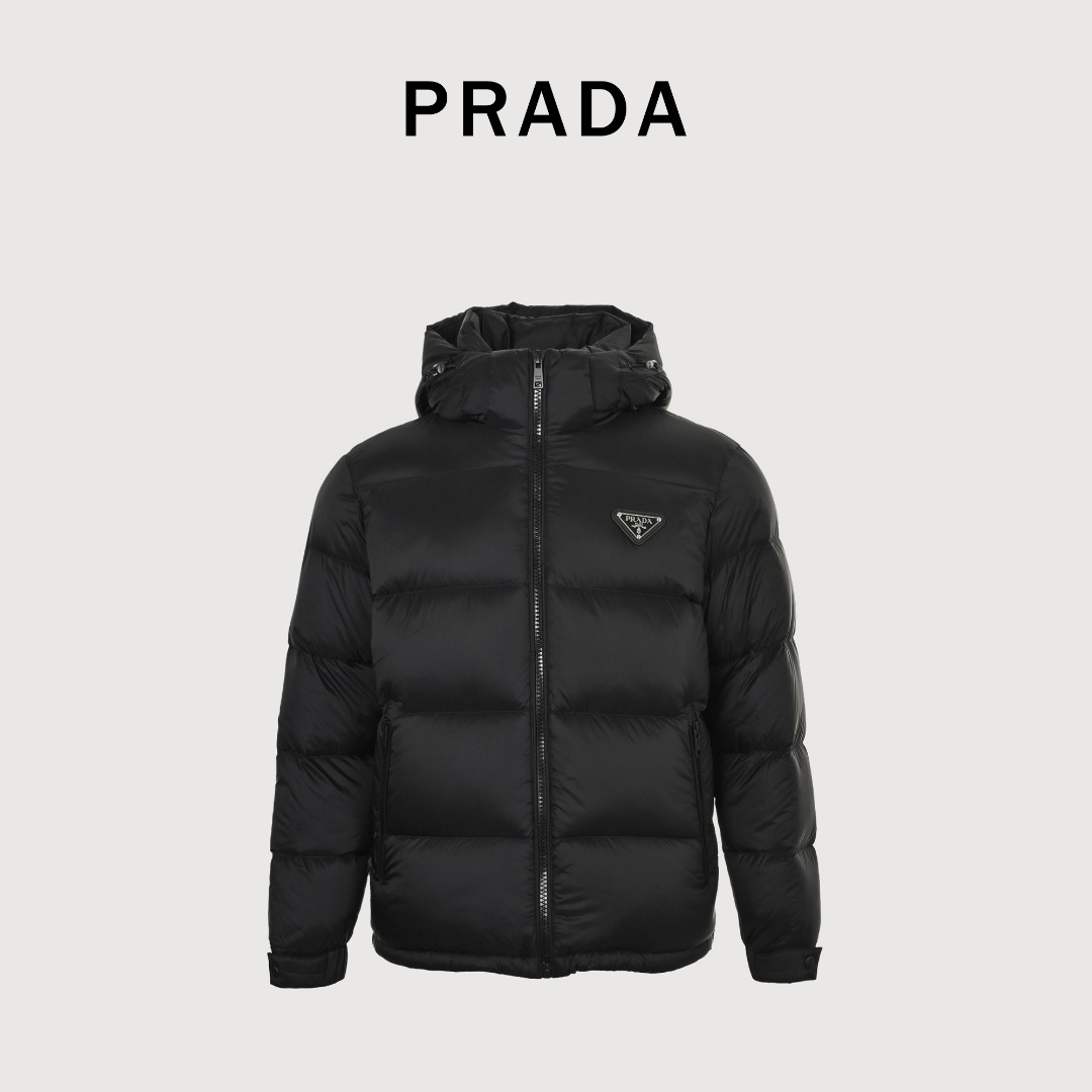 本地自取💰550
PRADA普拉达PRD 三角布标立领羽绒服
选用品牌标志性的尼龙面料，与传统尼龙性能相当，具备高强度，抗撕裂，耐磨损等特性。其质地轻盈，同时又具备防水功能适合多场景需求。抗皱，快干的特点也易于日常打理维护。（拆解原版、分析面料打色 还原无色差）
将尼龙织物材料平整的固定在冲压机台上，在电脑控制下，驱动上模以极高的速度和压力向下运动，锋利的刃口在压力下，像裁纸刀一样瞬间干净的切断尼龙布纤维，整个过程在毫秒内完成。通过精确的计算形成边缘无毛刺和拉丝的三角标形。最后通过绣花机沿着较小的三角标边缘将两块一大一小的三角标缝制于前片之上，走线均匀平整。
选用90白鸭绒，克重达220g，确保保暖性能卓越。绒子经过严格筛选与处理之后，不易钻绒，保证了耐用性。
Size：S-XL