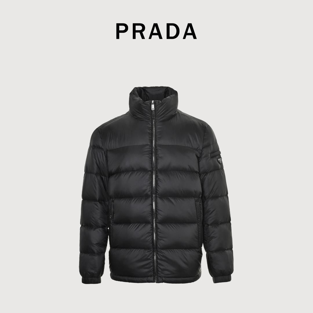 本地自取 💰650
Prada/普拉达 25Fw手臂三角标口袋立领羽绒服
采用新国标90白鸭绒填充，顶级版本，区分市面通货，男女同款全新美学灵感趣味设计,渠道性质精品。让整体造型设计更加优雅时尚，今夏最火系列，无数明星潮人追捧。裁剪工艺细节处理工整为玩味时尚增添色彩!工整细致，合身的版型构造更是独具匠心，上身不仅有着出彩的辨识度更是减龄青春。一款穿着意义还有穿搭性能都很极致的款式，绚丽的色系调配，此款的工艺必然也是极致非凡，上身的舒适度绝对足够的强大，也是奢品本质的一种彰显！柔软轻薄，触感更是极端撩人，透气性能十分之强大，尤为适合春夏季节的穿搭所需，妥妥的穿着享受，并且各处的细节以及织带的工艺都是尽善尽美，更显高级感！ 
颜色：黑色、藏青
编码：8026
尺码：48-56