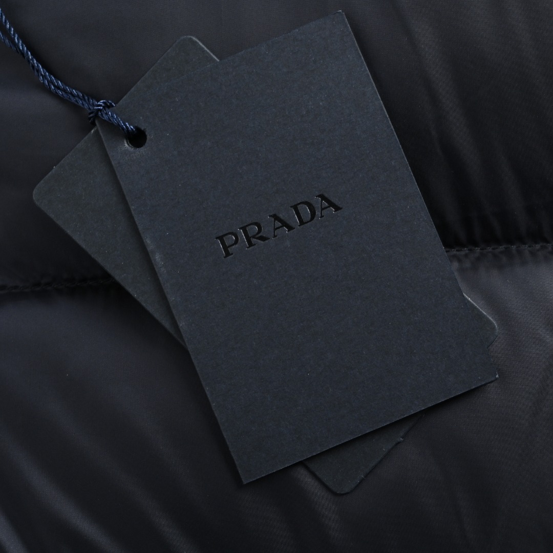 本地自取 💰650
Prada/普拉达 25Fw手臂三角标口袋立领羽绒服
采用新国标90白鸭绒填充，顶级版本，区分市面通货，男女同款全新美学灵感趣味设计,渠道性质精品。让整体造型设计更加优雅时尚，今夏最火系列，无数明星潮人追捧。裁剪工艺细节处理工整为玩味时尚增添色彩!工整细致，合身的版型构造更是独具匠心，上身不仅有着出彩的辨识度更是减龄青春。一款穿着意义还有穿搭性能都很极致的款式，绚丽的色系调配，此款的工艺必然也是极致非凡，上身的舒适度绝对足够的强大，也是奢品本质的一种彰显！柔软轻薄，触感更是极端撩人，透气性能十分之强大，尤为适合春夏季节的穿搭所需，妥妥的穿着享受，并且各处的细节以及织带的工艺都是尽善尽美，更显高级感！ 
颜色：黑色、藏青
编码：8026
尺码：48-56
