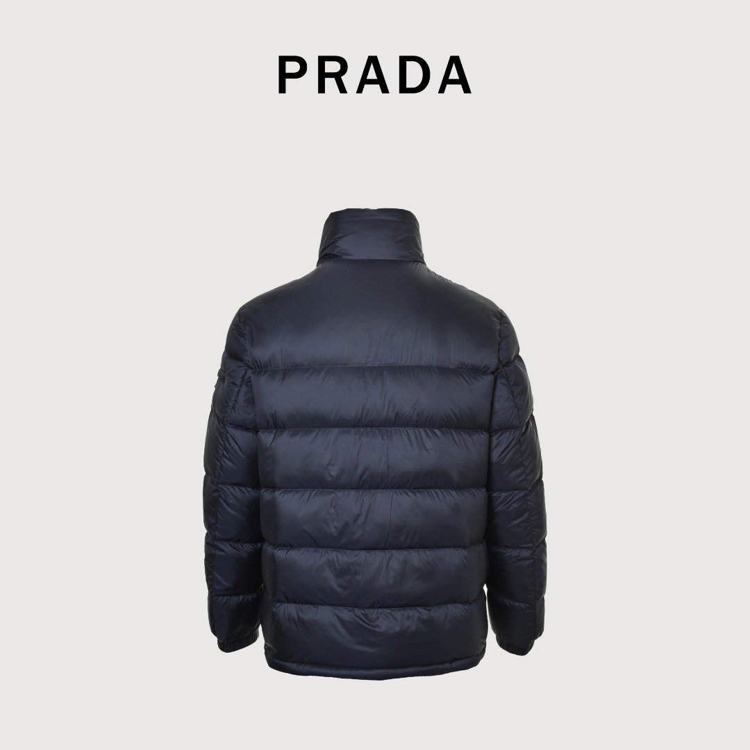 本地自取 💰650
Prada/普拉达 25Fw手臂三角标口袋立领羽绒服
采用新国标90白鸭绒填充，顶级版本，区分市面通货，男女同款全新美学灵感趣味设计,渠道性质精品。让整体造型设计更加优雅时尚，今夏最火系列，无数明星潮人追捧。裁剪工艺细节处理工整为玩味时尚增添色彩!工整细致，合身的版型构造更是独具匠心，上身不仅有着出彩的辨识度更是减龄青春。一款穿着意义还有穿搭性能都很极致的款式，绚丽的色系调配，此款的工艺必然也是极致非凡，上身的舒适度绝对足够的强大，也是奢品本质的一种彰显！柔软轻薄，触感更是极端撩人，透气性能十分之强大，尤为适合春夏季节的穿搭所需，妥妥的穿着享受，并且各处的细节以及织带的工艺都是尽善尽美，更显高级感！ 
颜色：黑色、藏青
编码：8026
尺码：48-56