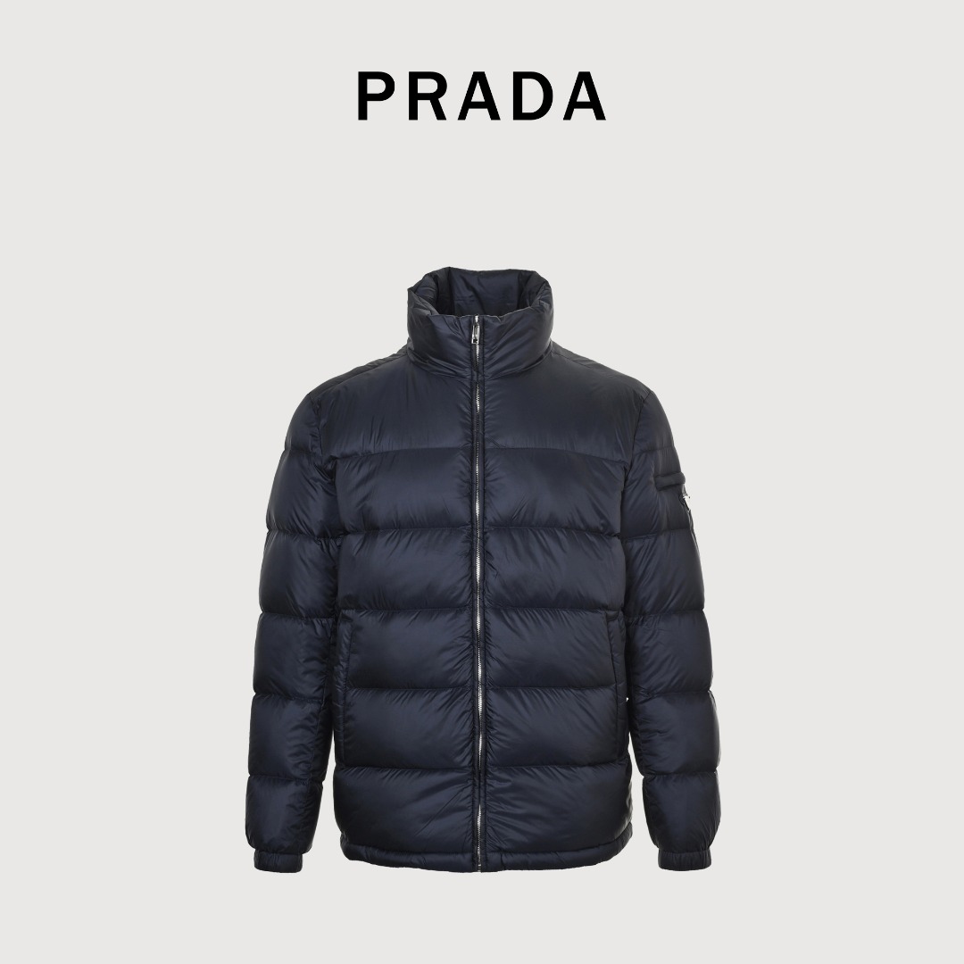 本地自取 💰650
Prada/普拉达 25Fw手臂三角标口袋立领羽绒服
采用新国标90白鸭绒填充，顶级版本，区分市面通货，男女同款全新美学灵感趣味设计,渠道性质精品。让整体造型设计更加优雅时尚，今夏最火系列，无数明星潮人追捧。裁剪工艺细节处理工整为玩味时尚增添色彩!工整细致，合身的版型构造更是独具匠心，上身不仅有着出彩的辨识度更是减龄青春。一款穿着意义还有穿搭性能都很极致的款式，绚丽的色系调配，此款的工艺必然也是极致非凡，上身的舒适度绝对足够的强大，也是奢品本质的一种彰显！柔软轻薄，触感更是极端撩人，透气性能十分之强大，尤为适合春夏季节的穿搭所需，妥妥的穿着享受，并且各处的细节以及织带的工艺都是尽善尽美，更显高级感！ 
颜色：黑色、藏青
编码：8026
尺码：48-56