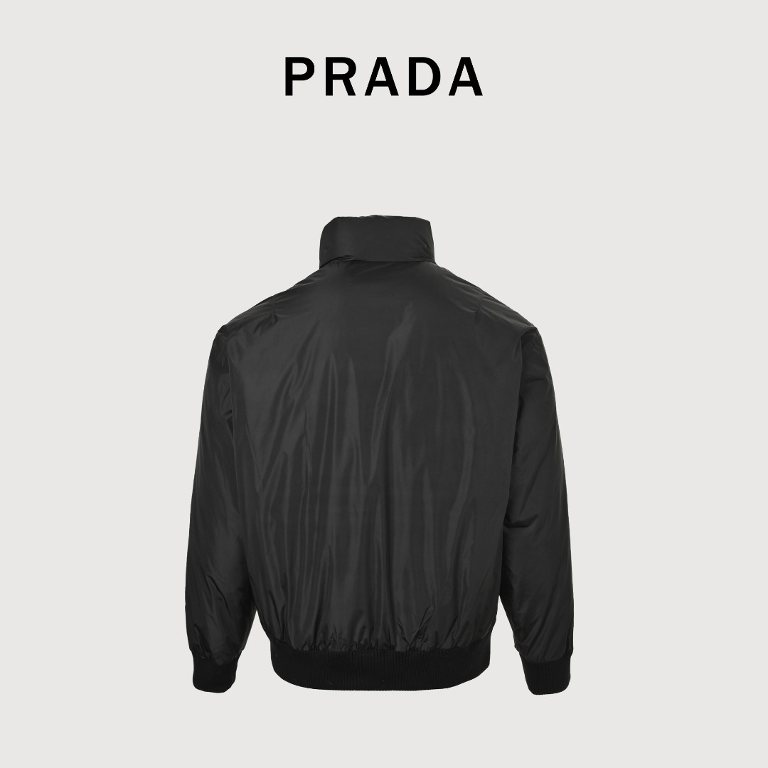 本地自取 💰600 
Prada/普拉达 25Fw下摆双边翻盖口袋薄绒外套
采用新国标90白鸭绒填充，顶级版本，区分市面通货，领口采用门扣设计，可调节，男女同款全新美学灵感趣味设计,渠道性质精品。让整体造型设计更加优雅时尚，今夏最火系列，无数明星潮人追捧。裁剪工艺细节处理工整为玩味时尚增添色彩!工整细致，合身的版型构造更是独具匠心，上身不仅有着出彩的辨识度更是减龄青春。一款穿着意义还有穿搭性能都很极致的款式，绚丽的色系调配，此款的工艺必然也是极致非凡，上身的舒适度绝对足够的强大，也是奢品本质的一种彰显！柔软轻薄，触感更是极端撩人，透气性能十分之强大，尤为适合春夏季节的穿搭所需，妥妥的穿着享受，并且各处的细节以及织带的工艺都是尽善尽美，更显高级感！ 
颜色：黑色
编码：8032
尺码：48-56